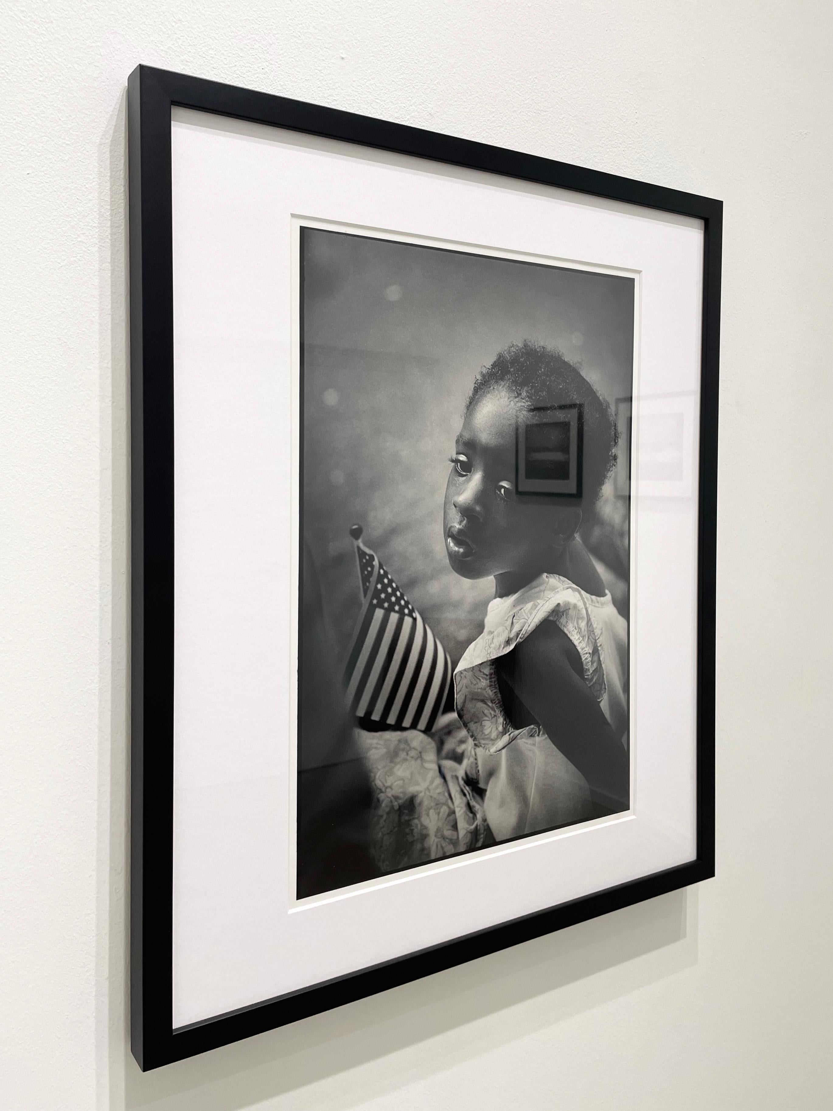 Ragazza con bandiera - Fotografia in bianco e nero, artista nero, bambino, ritratto - Black and White Photograph Grigio di Earlie Hudnall Jr.