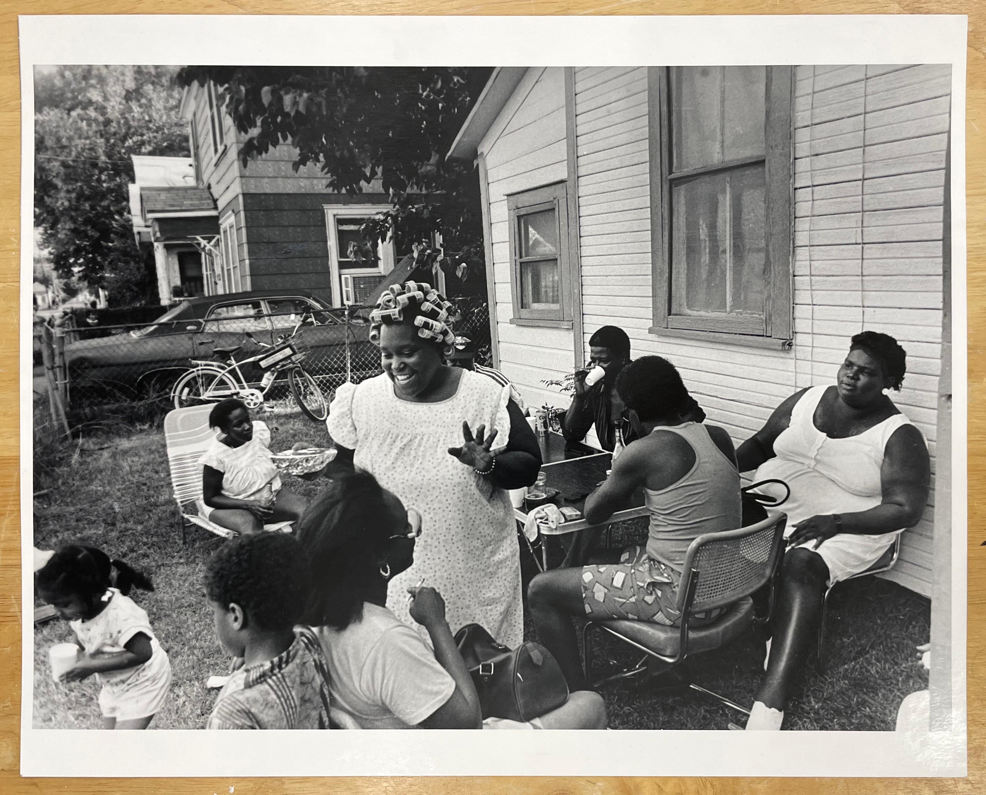 June 19th by Earlie Hudnall, Jr., is a black and white photograph documenting a family's celebration of Juneteenth, the day in which the last of the enslaved people in Texas were told of their freedom through the Emancipation Proclamation. 
This