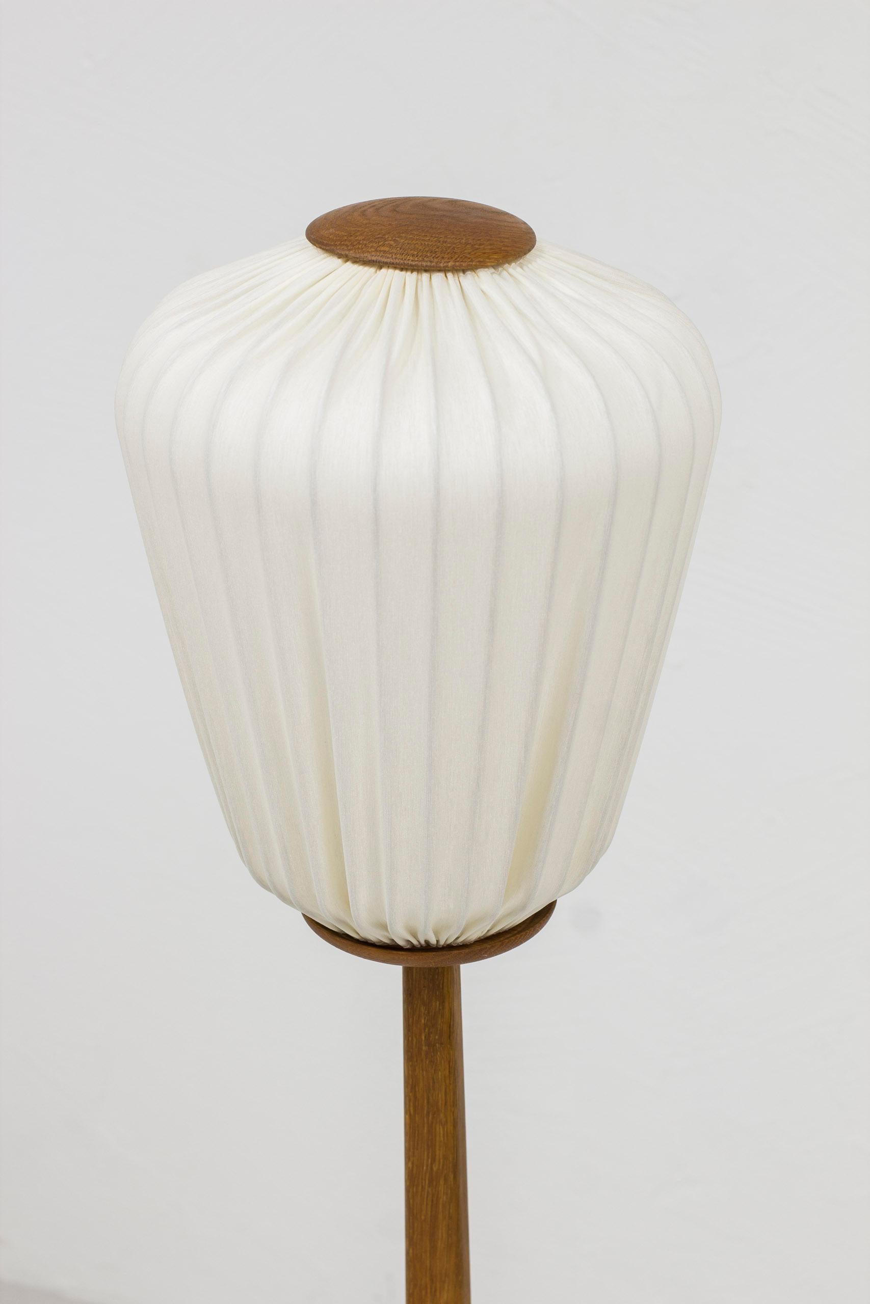 Swedish Earlt floor lamp in oak and fabric by Luxus, Uno Kristiansson, Sweden, 1950s For Sale