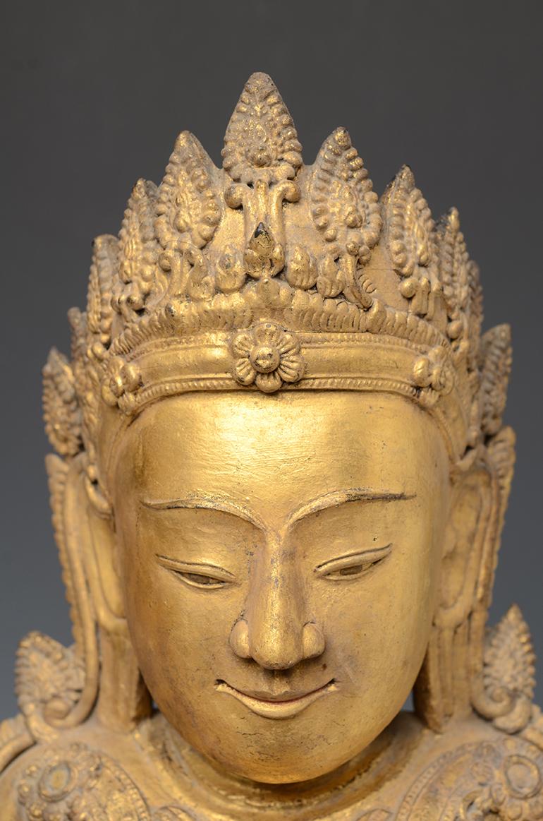 Burmese wooden crowned Buddha with gilded gold or sometimes known as 'King Buddha's, wearing diadem-crowns and ornaments of kings instead of ordinary monk's robes. 

Age: Burma, Early Ava Period, Early 15th Century
Size: Height 60.7 C.M. / Width 29