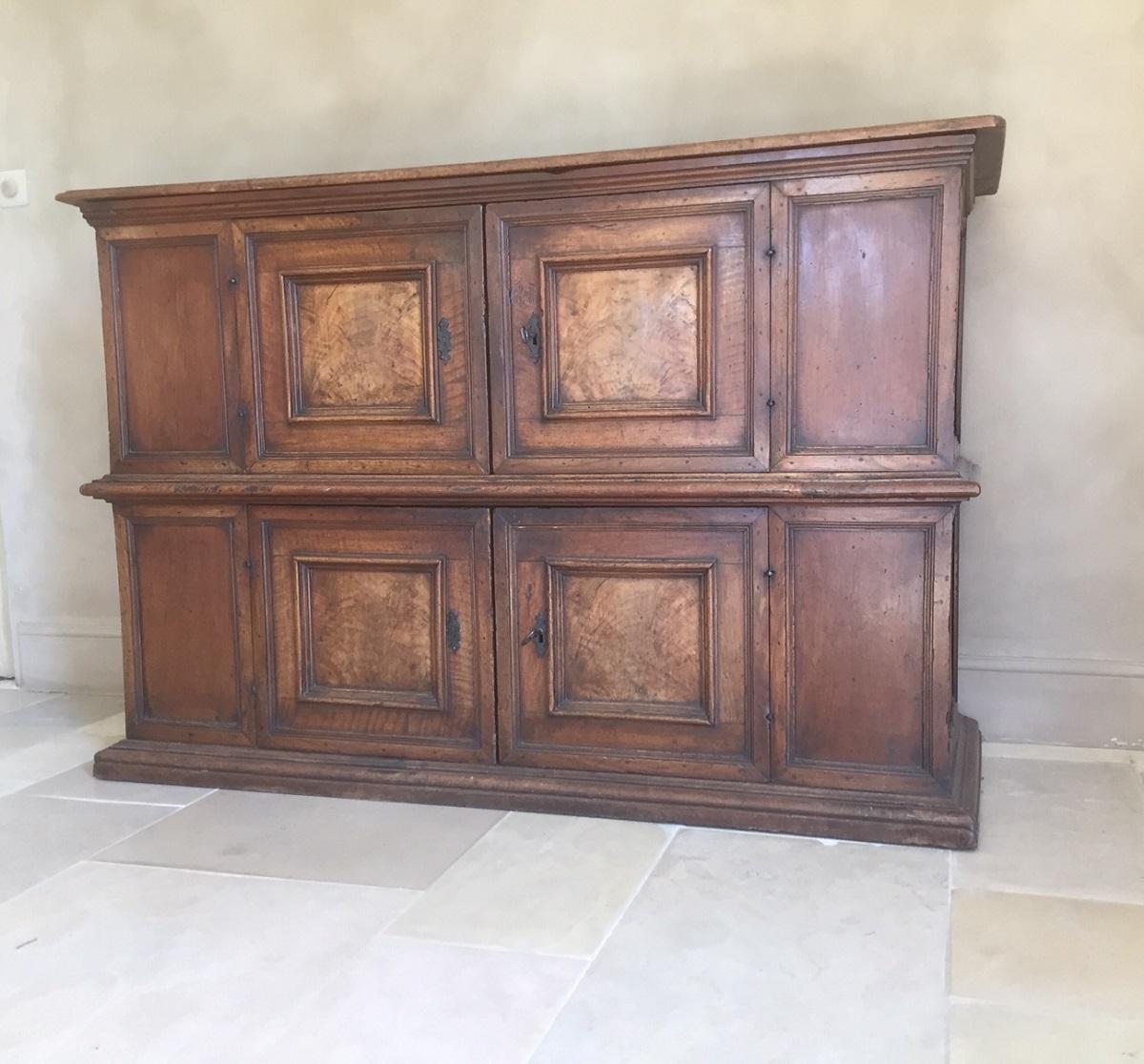 A early 17th century Italian credenza cupboard. Beautifully executed in walnut with solid burr walnut panels. The top hinges open and can be closed with a interior lock system.
This type of cupboard is to be situated in the very early stages of