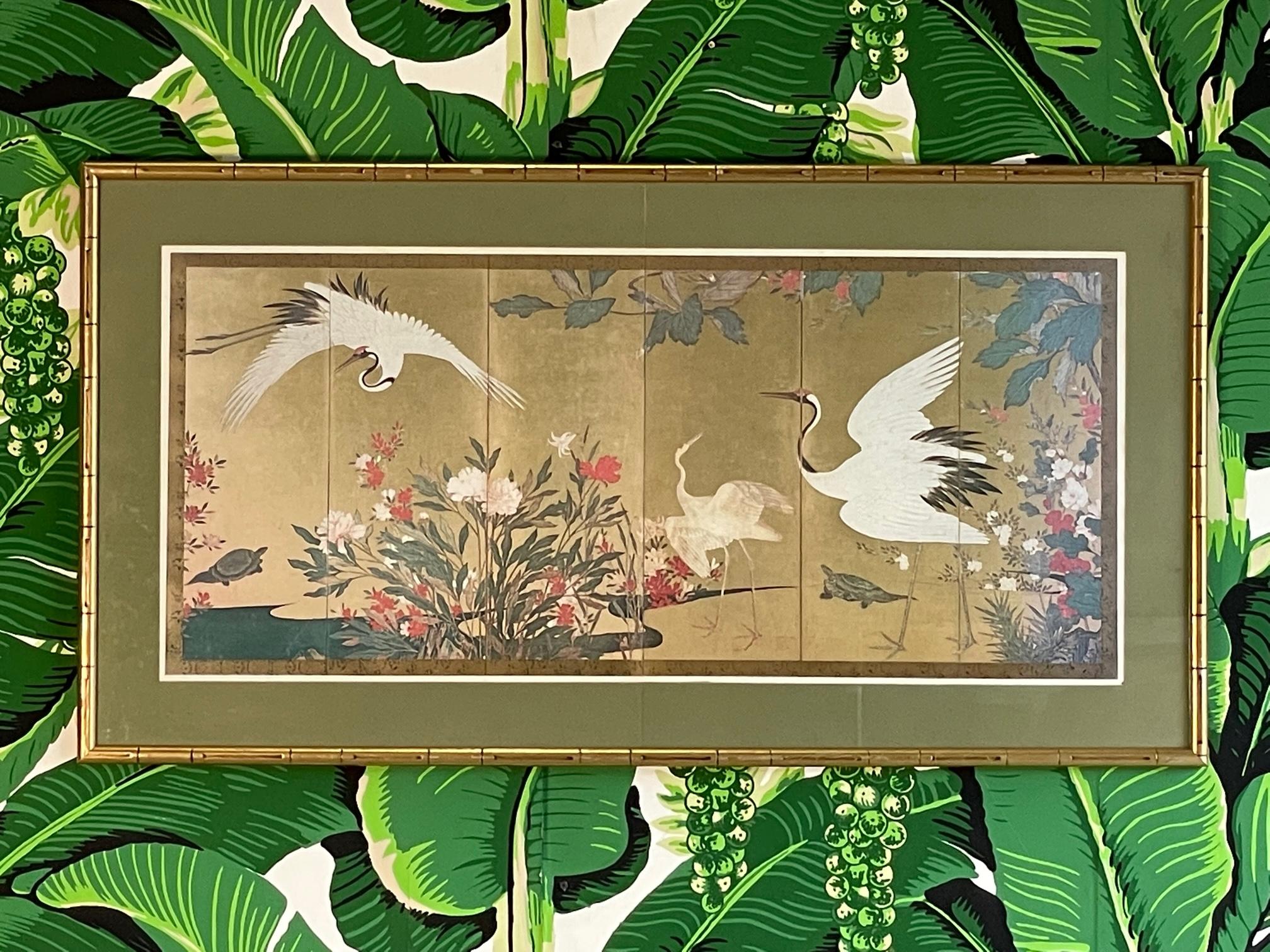 Estampe encadrée d'art japonais représentant des grues et de la flore, estimée vers la fin du XVIe ou le début du XVIIe siècle. Encadré en bois sculpté en faux bambou et doré. Bon état avec des imperfections correspondant à l'âge, voir les photos