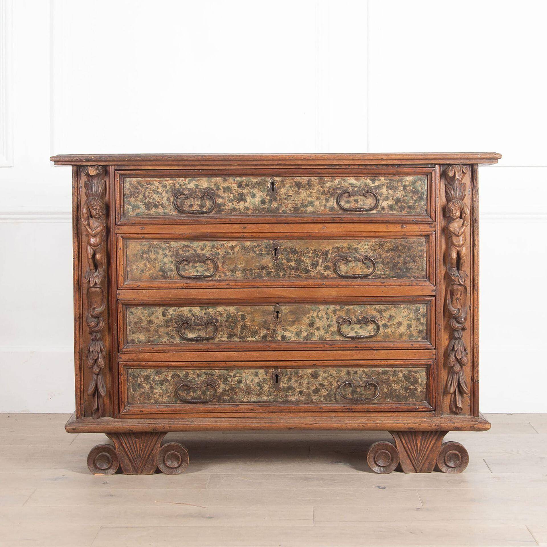 Fabulous early 17th Century Italian faded walnut Bambocci commode. 

With carved putti mounted on richly carved foliate pilasters flanking four original faux marble painted drawers and retaining their original ironwork. 

Standing on unusual twin