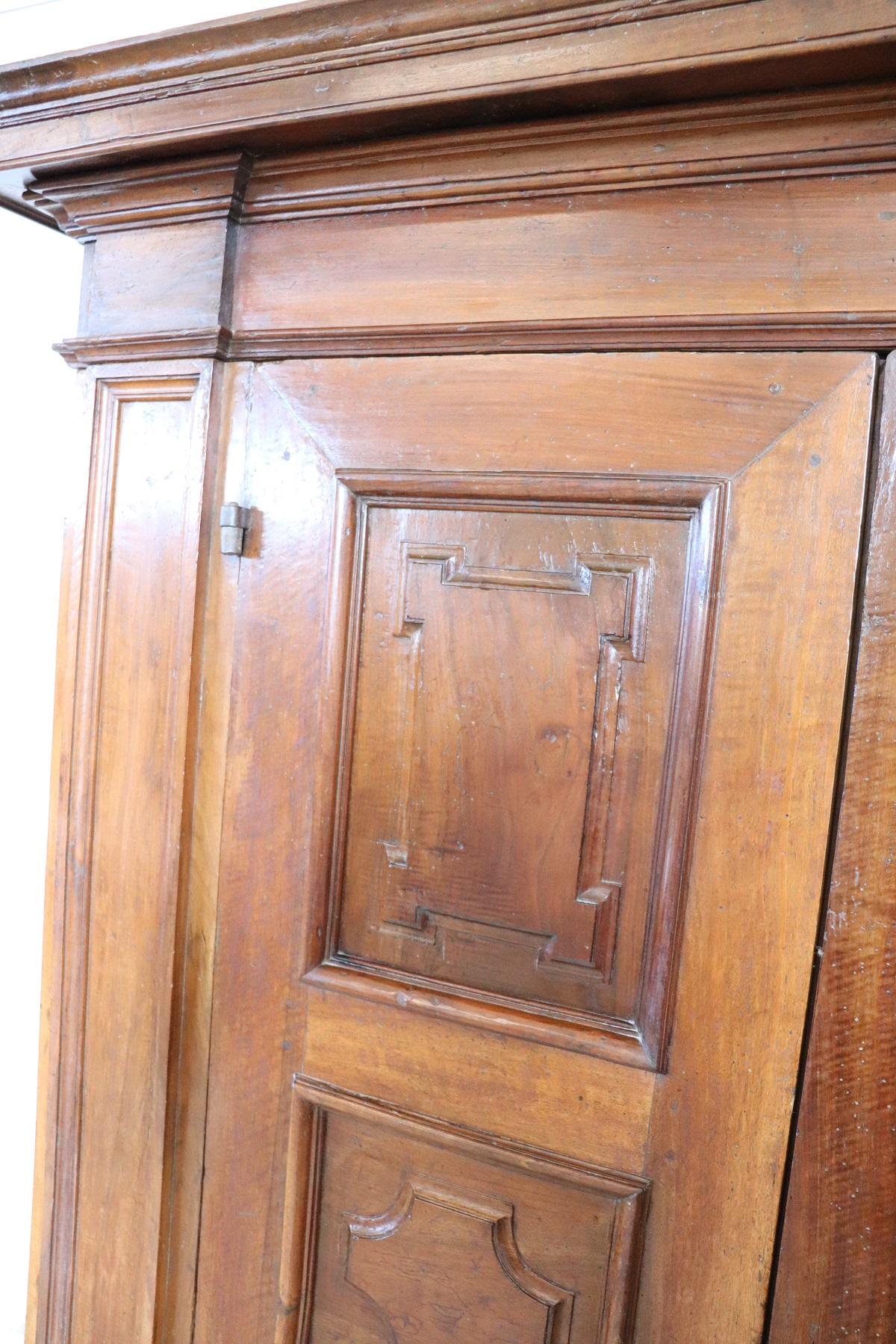 Rare and important antique wardrobe in solid walnut made in the early 17th century Italian Baroque Louis XIV. The line is in fact typical of this period of high period that wanted this type of furnishings of great grandeur made of solid walnut wood