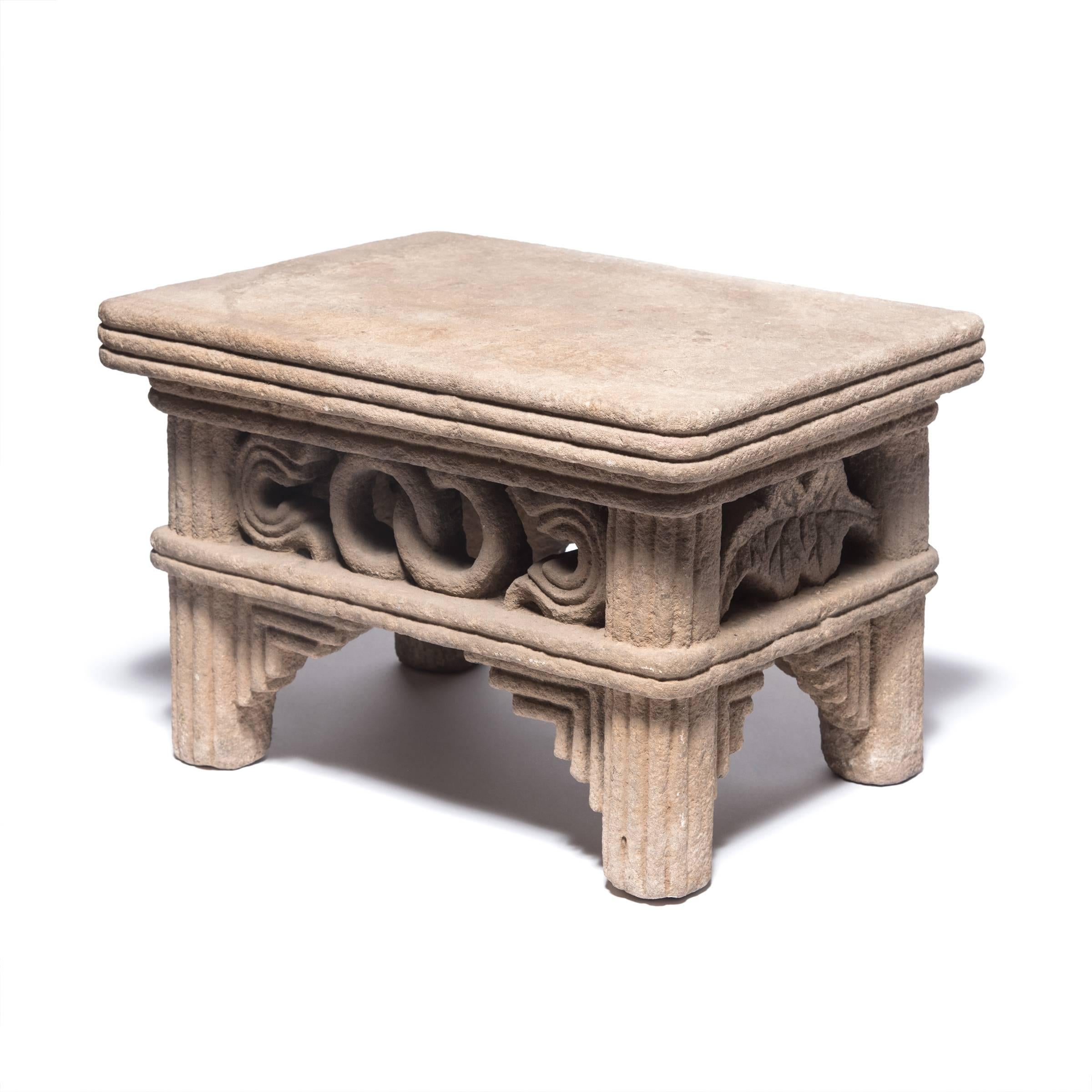 Dieser niedrige Tisch aus der späten Ming-/frühen Qing-Dynastie wurde vor über 400 Jahren von Hand aus einem einzigen Kalksteinblock gehauen. Der Tisch hat Schürzen mit ineinandergreifenden Ringen, Symbolen der Ewigkeit, und mit Perlen besetzte