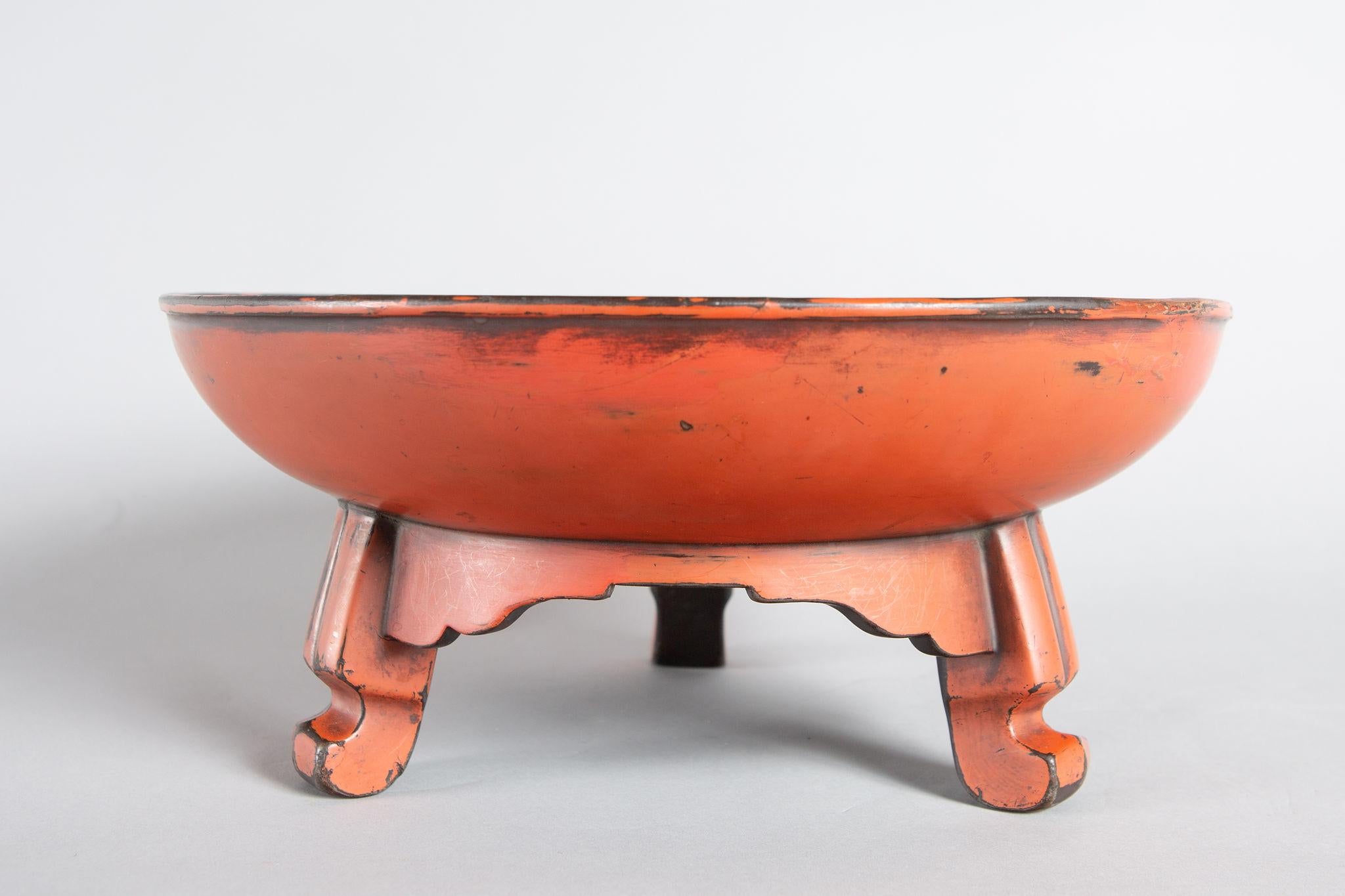 Early 17th century Negoro lacquer footed bowl, Edo period (1603-1868) round bowl with tripod cabriole style legs. Negoro lacquer (monk's lacquer in red with traces of black under lacquer).