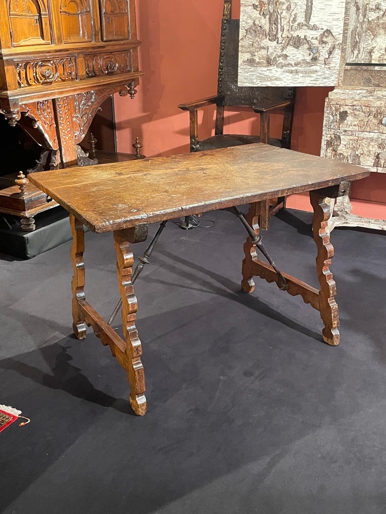 This particular type of table was invented by 16th century Spanish cabinetmakers.

This elegant table can easily be taken apart. Its rectangular top is assembled to the legs with iron hooks.
It stands on scrolled lyre shaped supports joined by