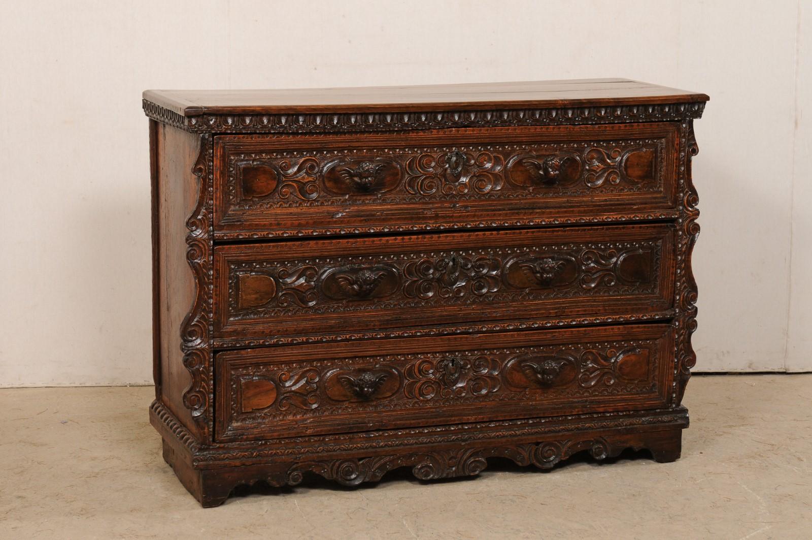 Commode italienne en noyer finement sculptée du début du XVIIIe siècle. Ce coffre ancien d'Italie a été orné de magnifiques sculptures tout au long de son parcours, des moulures de la garniture en forme de cœur d'œuf aux ailes 