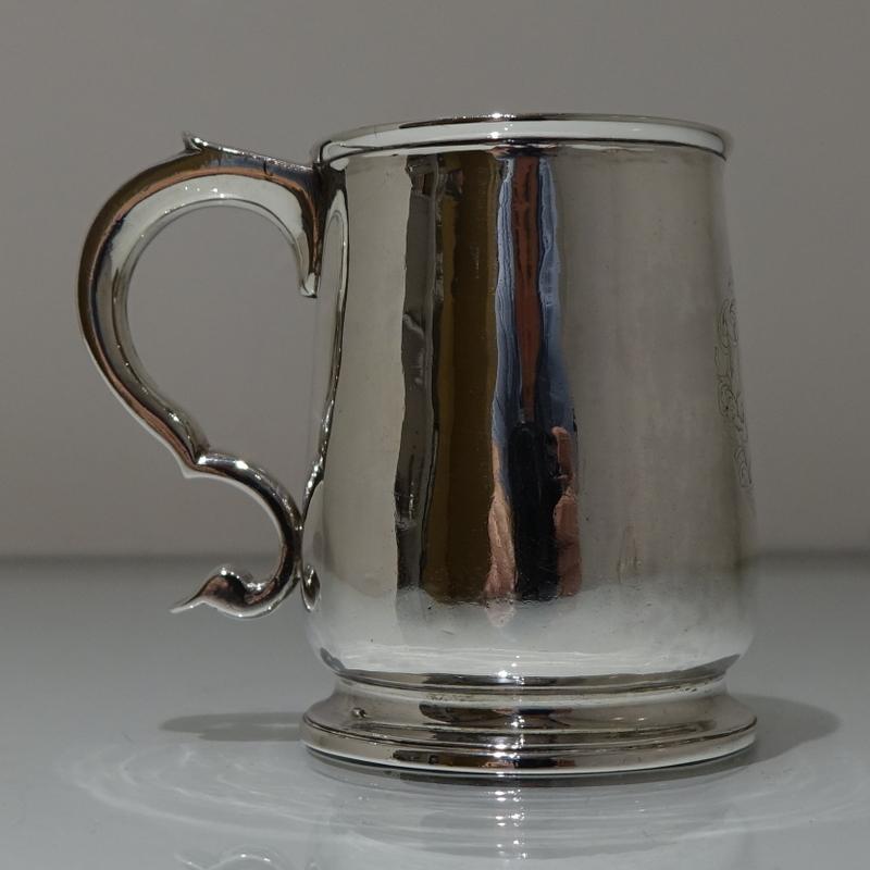 A very elegant 18th century tapered half pint mug with a double scroll handle. The base is slightly tucked above the cast applied spreading foot. The centre front has an elegant contemporary armorial for importance.

Weight: 6.9 troy ounces/216