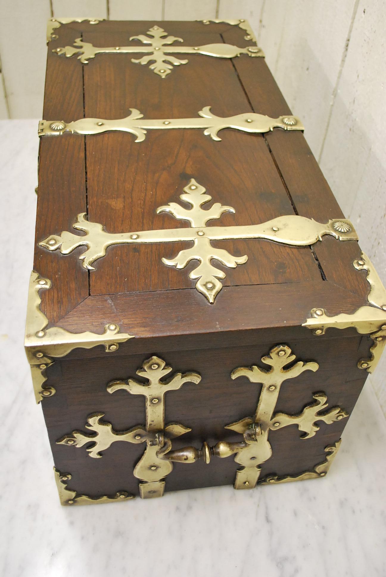 A rare and unusual Spanish strong box / treasure chest, made in solid padauk. Excellent color and patination, decorated with ornate fretted brass straps, carrying handles and corner brackets. A later hasp on the lock that is in keeping with the