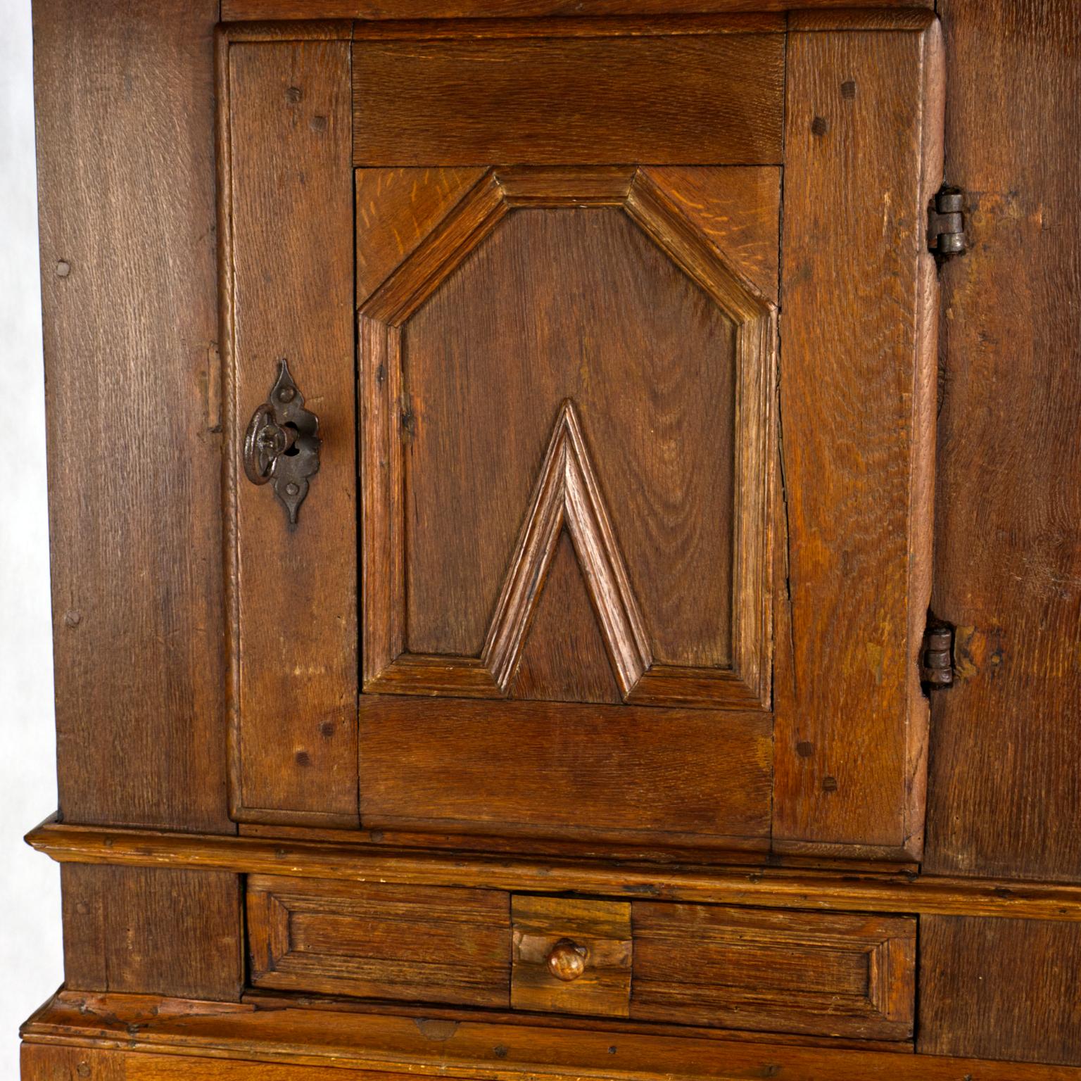 This amazing Danish Baroque oak cabinet is made at the beginning 18th century. In the past, the lower drawer was apparently repaired by a folk carver. The cabinet has an original and still functional lock with a massive original key. The entire