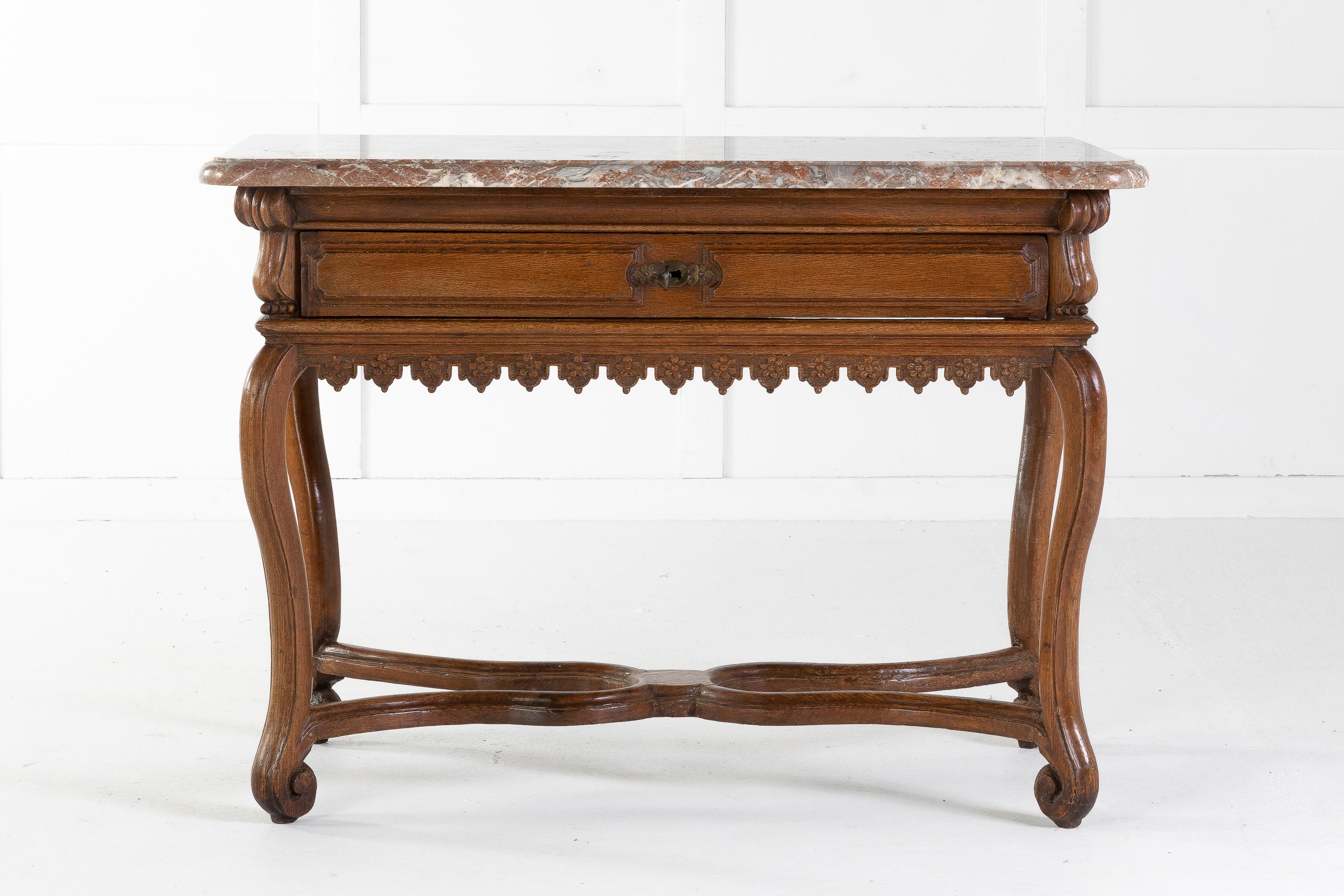Small, early 18th century Belgian oak side table. Retaining its original marble top, above a carved frieze with central, single carved drawer. Cabriole legs terminating in carved scroll feet and curvy cross stretcher.