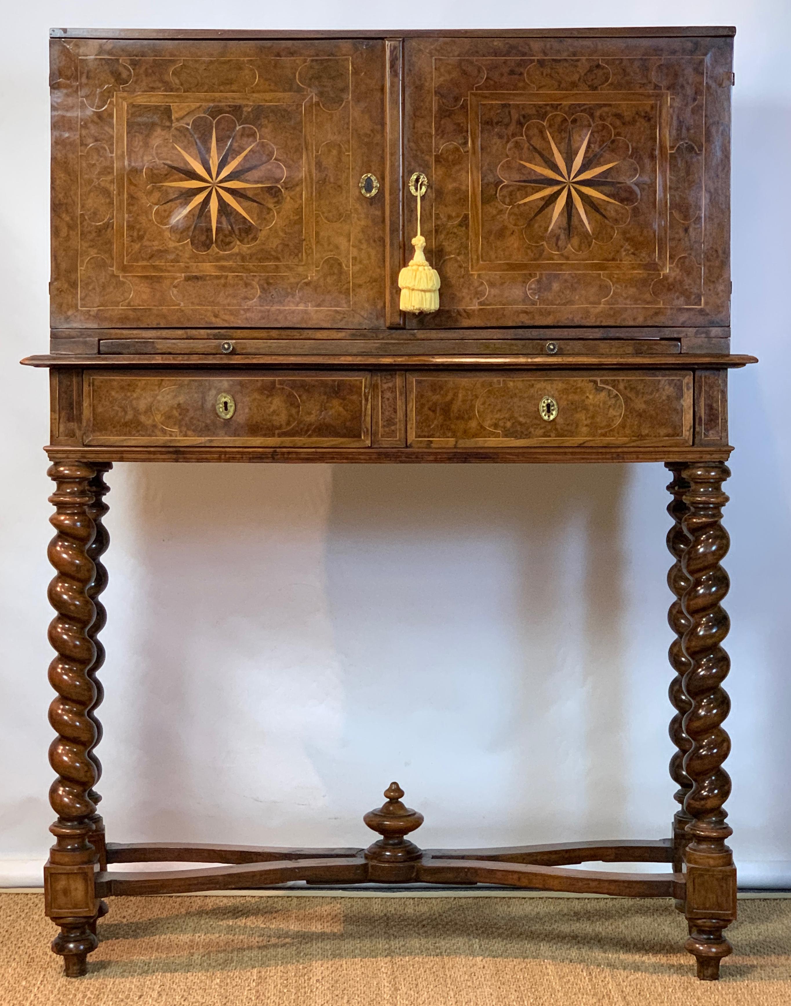 A handsome early 18th century Italian burl walnut chest on stand with elaborate inlay throughout resting on barley twist supports linked by carved stretchers. The interior of the cabinet is later fitted for use as a spirit cabinet with compartments