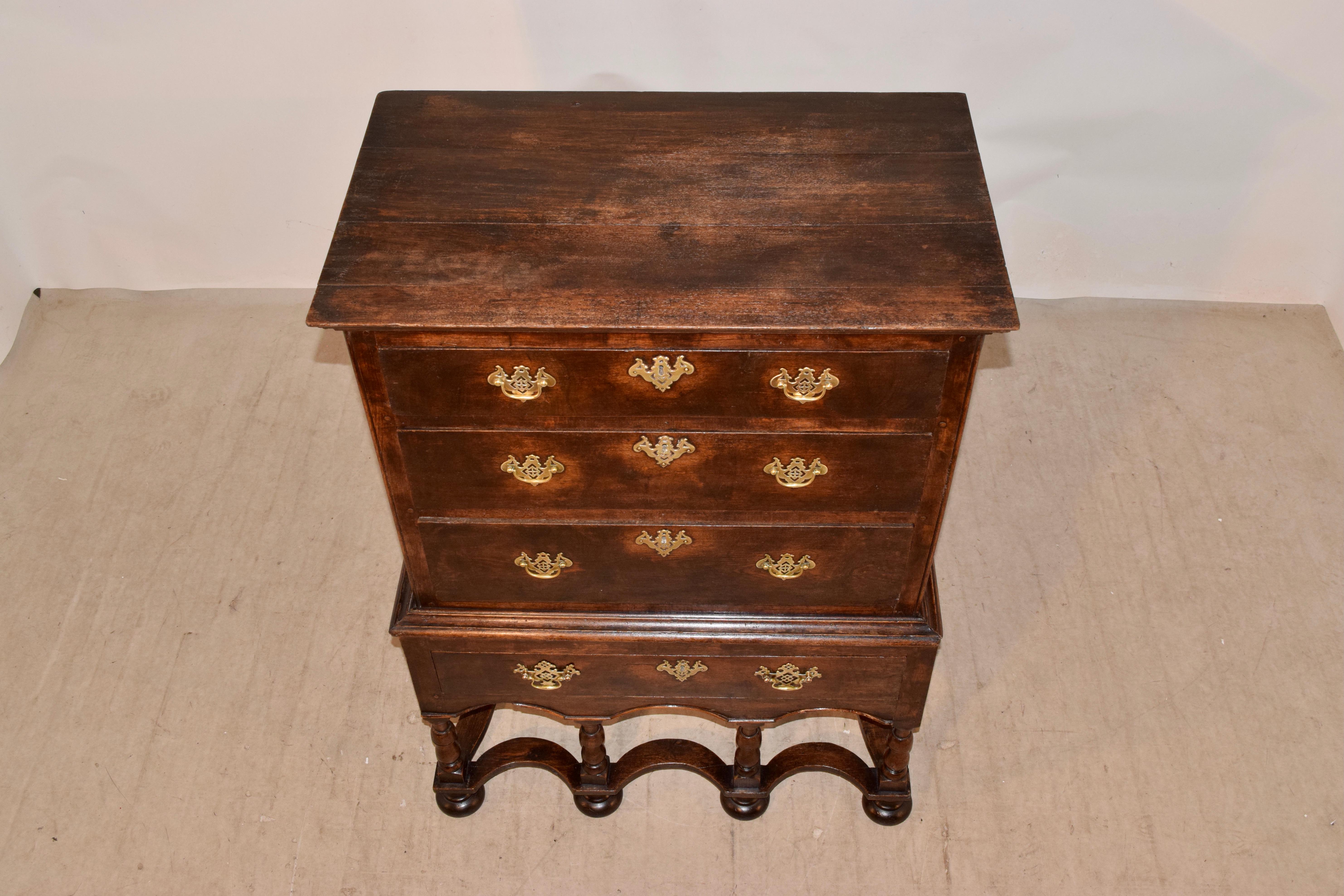 Early 18th century chest on stand from England made from oak. It has pegged construction throughout and features raised paneled sides and three drawers in the top portion of the chest. This rests on the base, which contains a single drawer over a