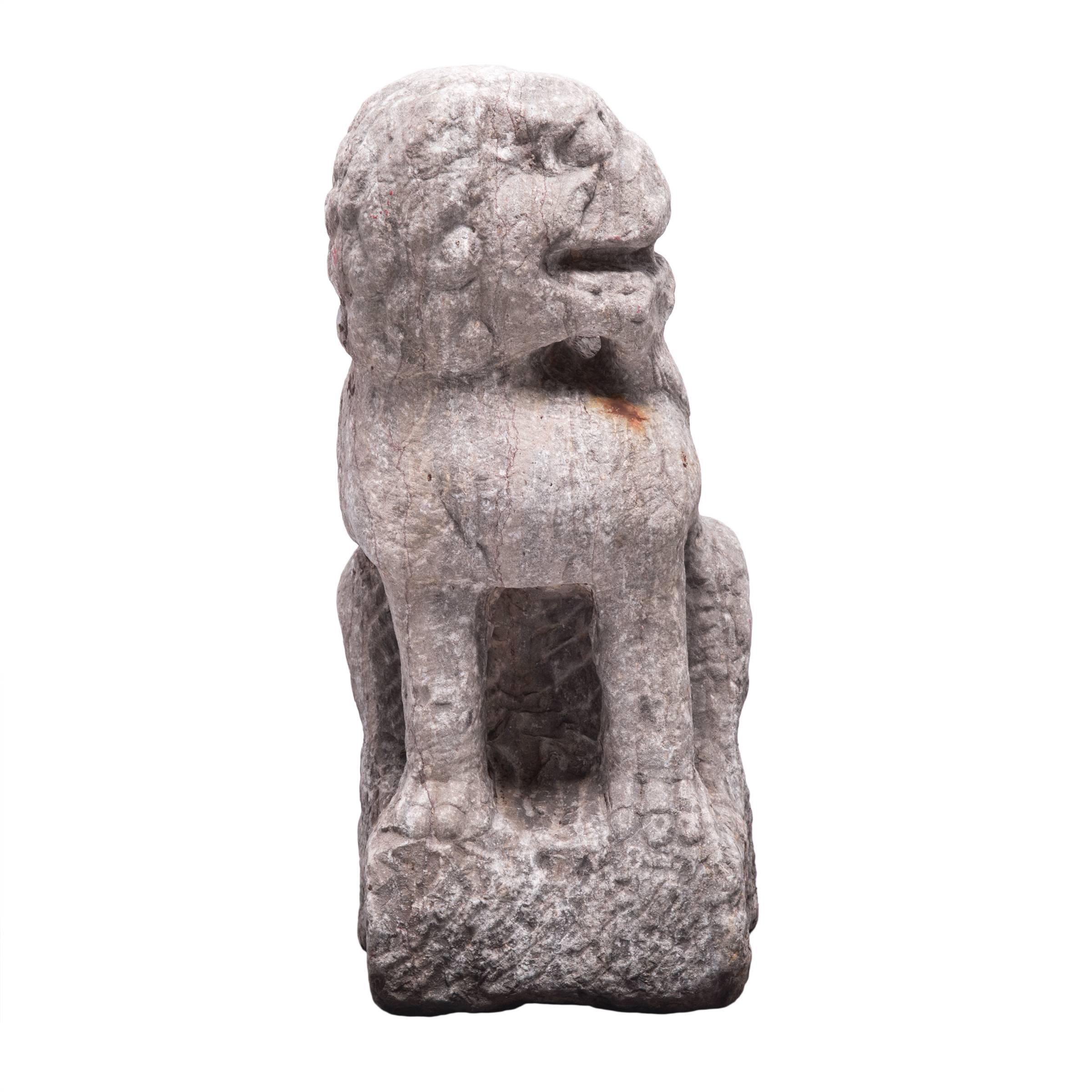 This early 18th century Shizi was carved by hand with a peaceful peering face from a single block of limestone. Shizi, meaning 