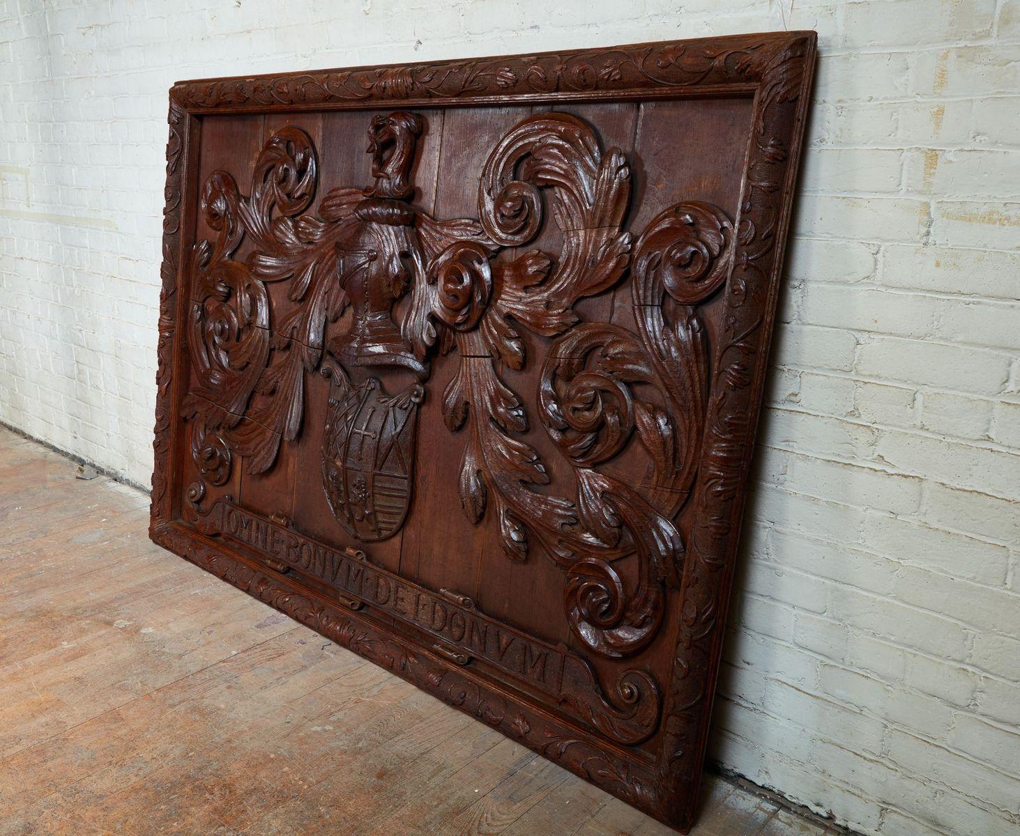 Rare and impressive early 18th century coat of arms, the whole carved in oak, the frame with relief carved strapwork on punched and worked ground surrounding coat of arms with foliate flourishes centered by a shield having a unicorn over a helmet