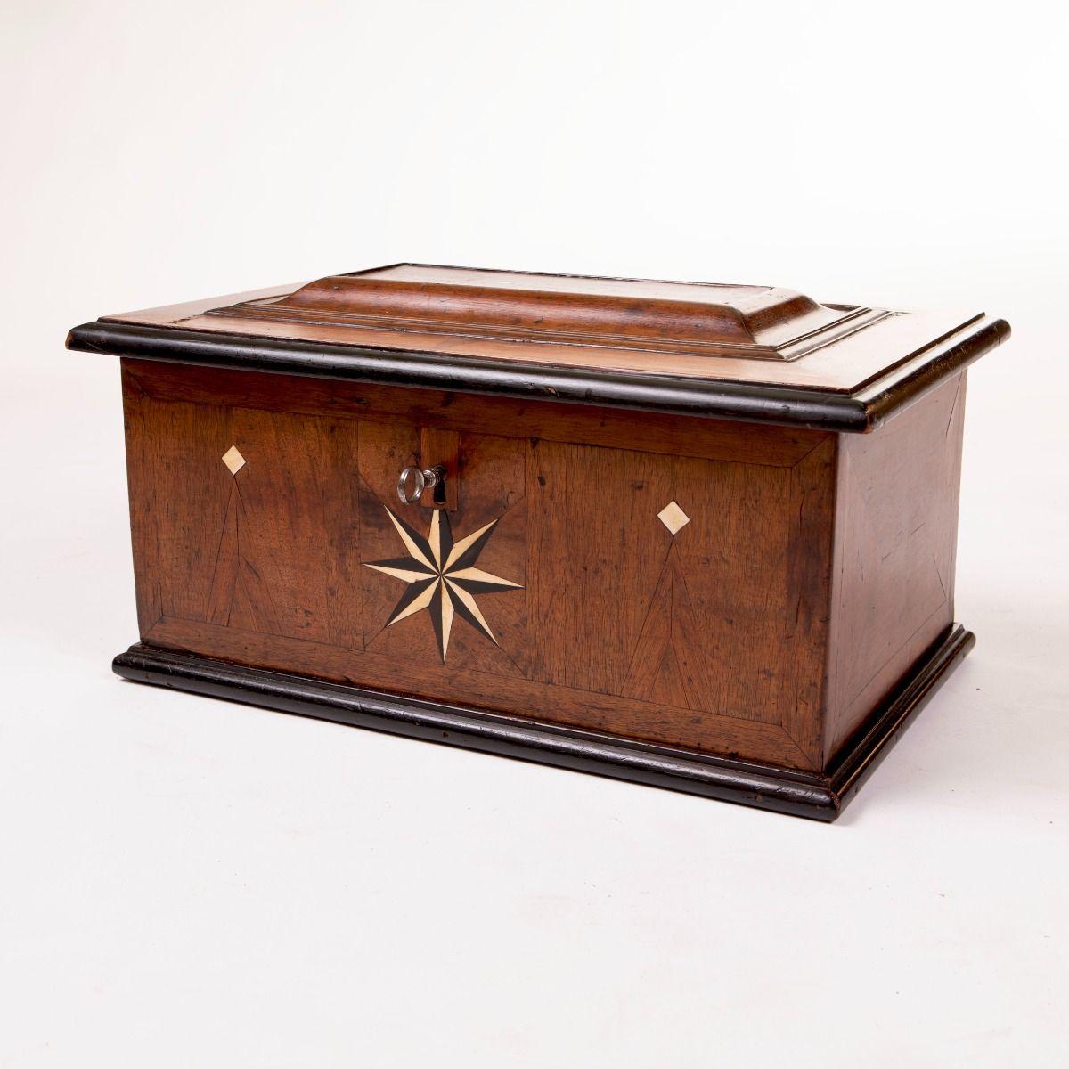 Elegant cercueil baroque en chêne, richement plaqué de noyer taillé à la main et terminé par des moulures ébonisées.

Le couvercle présente des panneaux de style baroque prononcés avec de délicates incrustations d'os et des bordures ébonisées