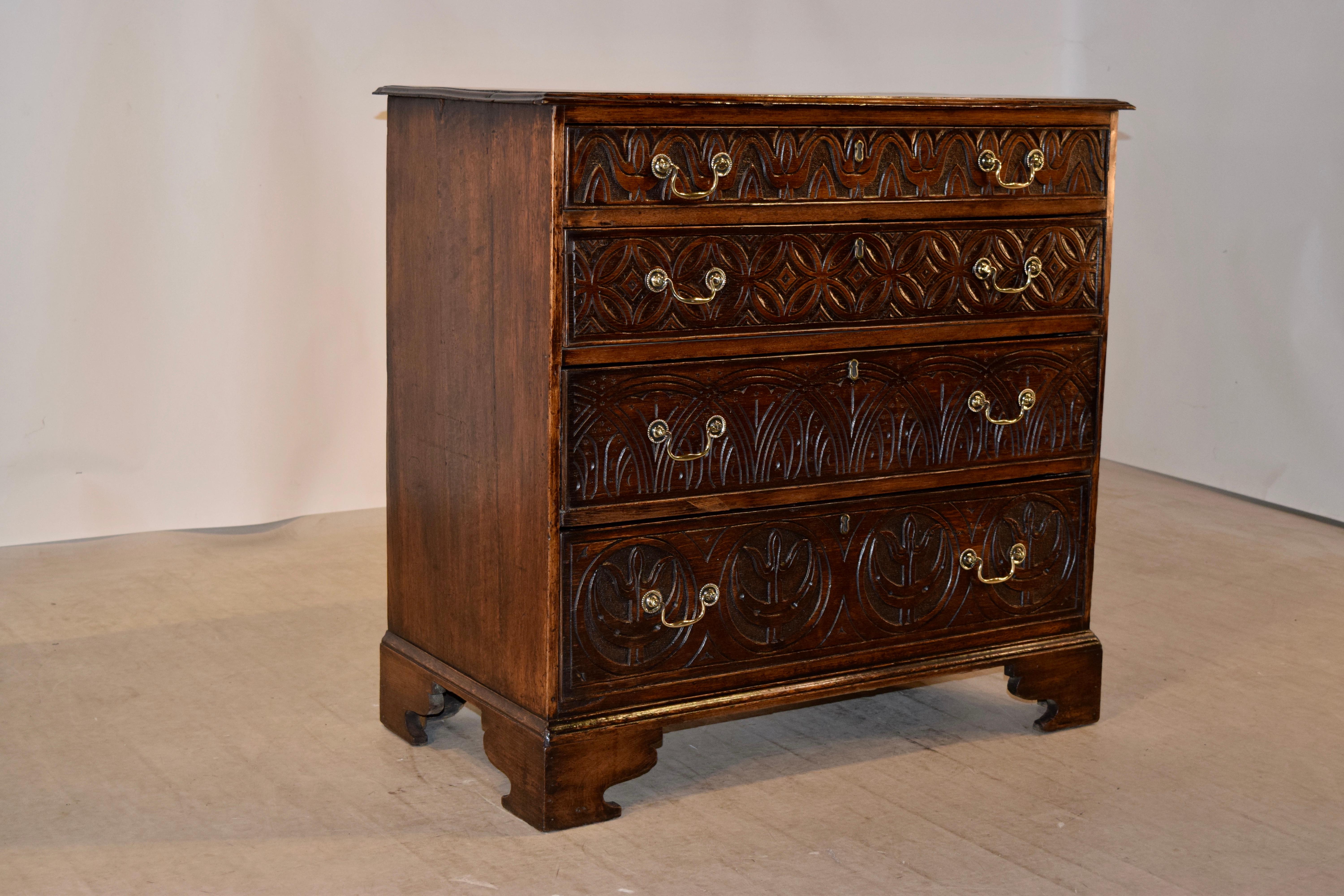 Early 18th century English oak chest with a bevelled edge around the top following down to simple sides and four drawers in the front, all with different hand carved decorations for a truly unique chest. The case is raised on hand carved bracket