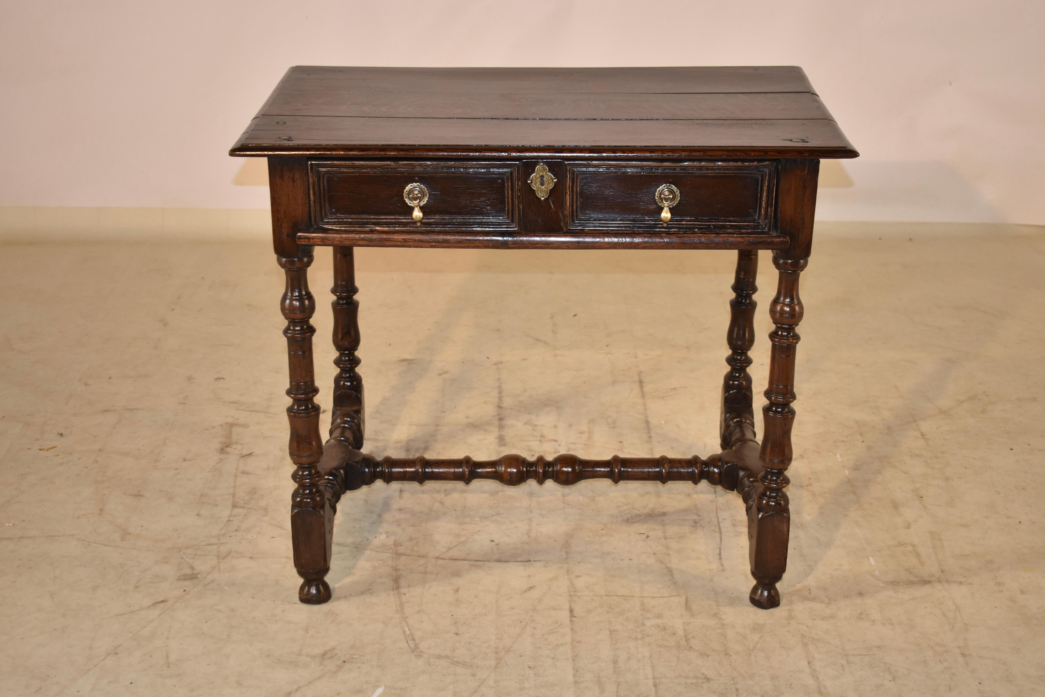 Late 17th-Early 18th century oak side table from England. The top is made from three boards, all with pegged construction and a beveled edge, following down to simple sides which feature a carved decorated band and a single drawer in the front,