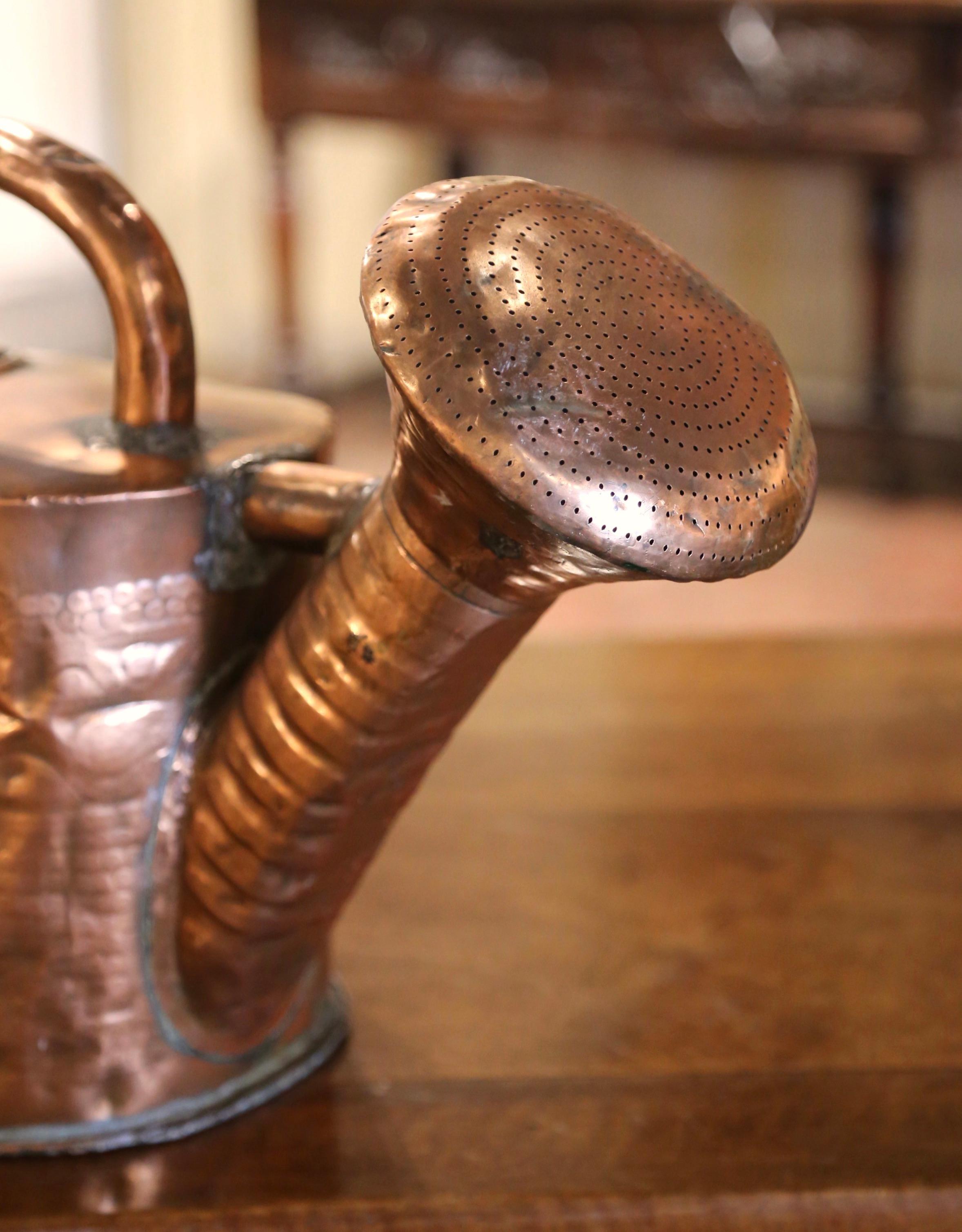 Decorate kitchen cabinets with this large antique water can. Hand crafted in Normandy France circa 1740, and built of copper, the hammered metal construction gives this watering can a charming and unique character. Designed with a gracefully curved