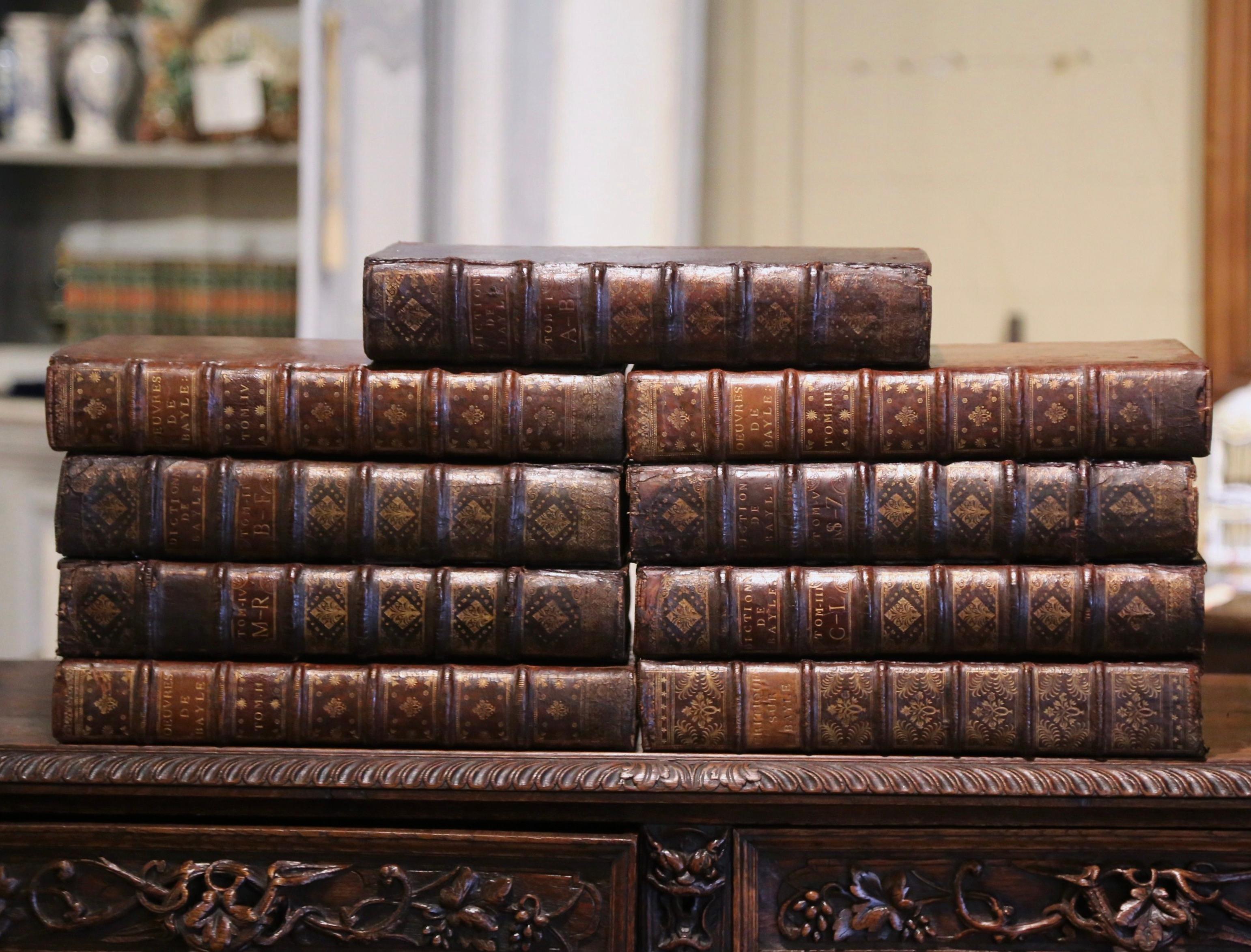 Décorez une bibliothèque ou un bureau avec cet ensemble de grands livres anciens. Datés de 1727 à 1748, et imprimés à Paris sous le règne du roi Louis XV, ces importants livres reliés en cuir présentent les éléments suivants :
 Ouvrage français