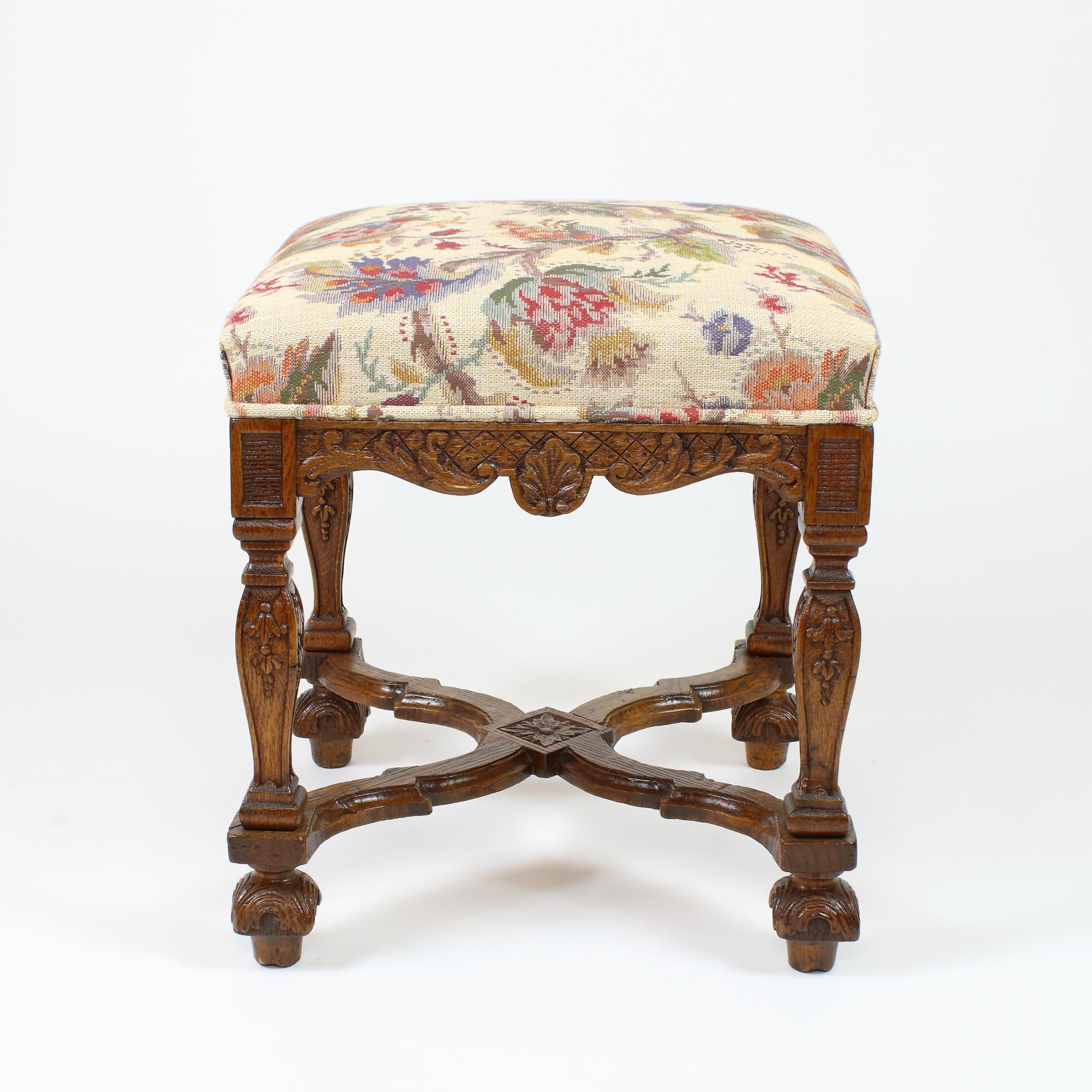 Early 18th Century Louis XIV/Régence Carved Oak stool or Tabouret

Square and upholstered seat resting on a shaped apron with c-scrolls, leafs and central shell motifs. The four legs are carved as square balusters decorated with flower garland