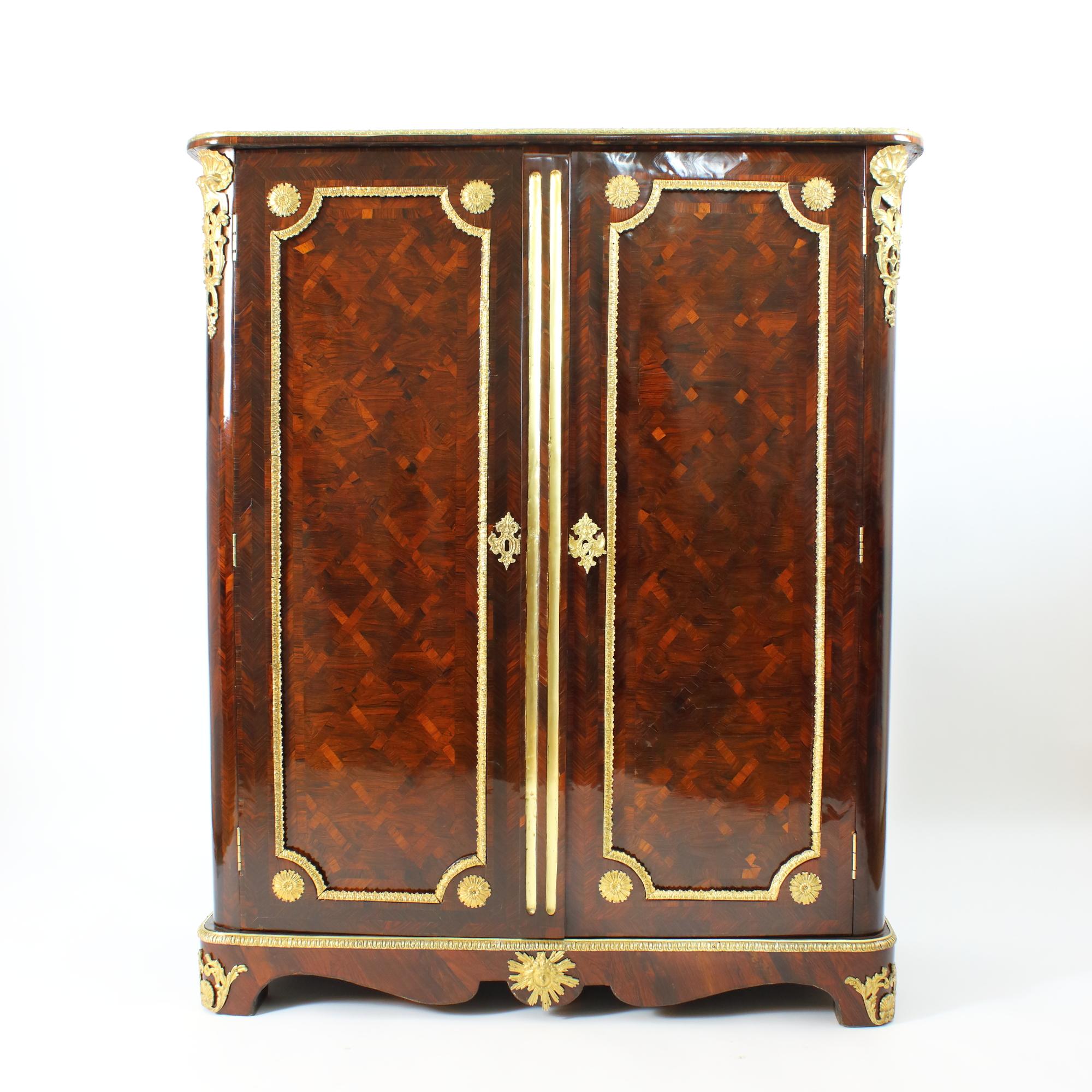 Early 18th Century French Louis XIV / Régence Marquetry Armoire or Wardrobe

The rectangular Louis XIV Régence armoire or wardrobe with rounded corners standing on a short base with bracket feet and curved apron with gilt-bronze Apollo head mount;