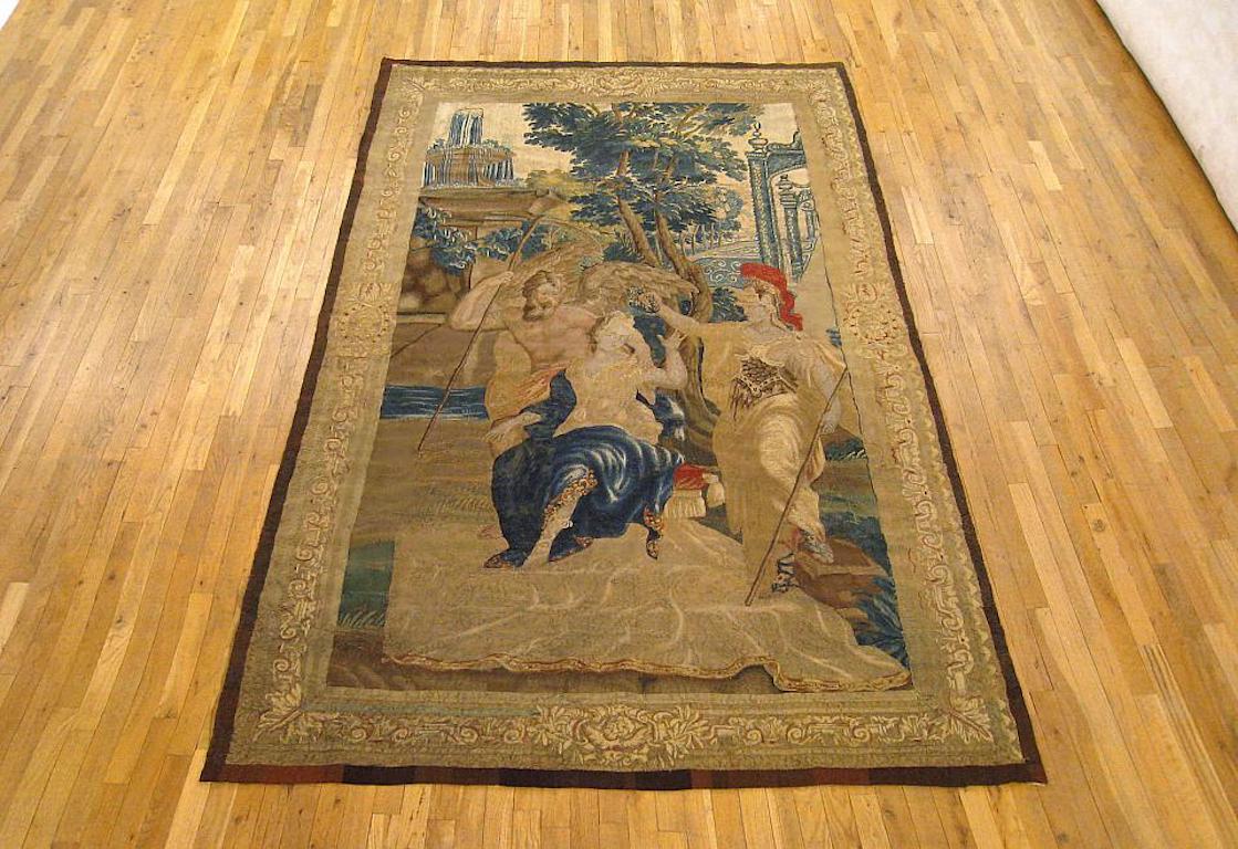 A French mythological tapestry from the early 18th century, depicting Father Time and Minerva flanking a seated female figure whom Minerva crowns with a laurel garland; a fountain in the upper left corner and formal gardens in the background.