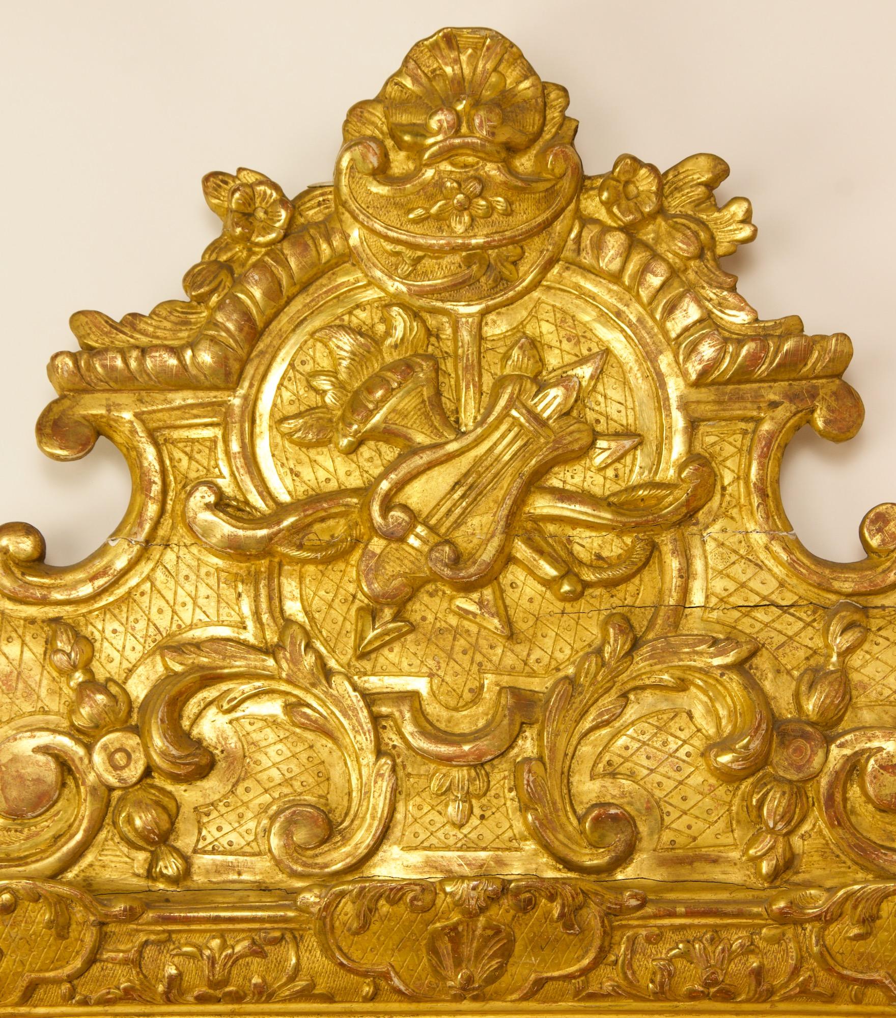 Early 18th century French regence love symbol giltwood mirror.

An early 18th century Regence giltwood mirror with a rectangular plate (17.72 in. x 13.38 in.) within a conforming frame adorned with a carved ionic egg-and-dart border and interlaced