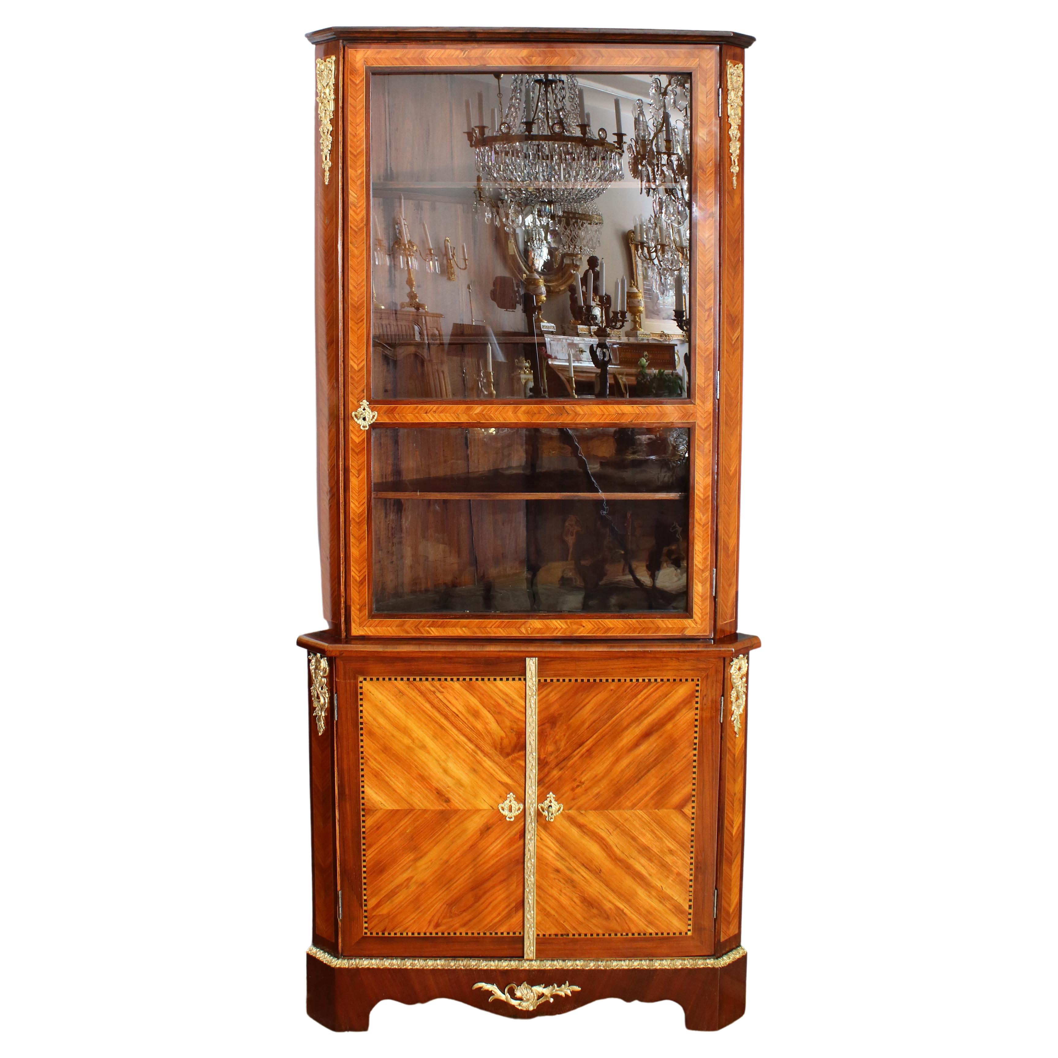 Early 18th Century French Régence Marquetry two-piece corner cabinet/ encoignure : 

lower cabinet section of triangular shape with canted corners on a base featuring a curved front with central ornamental apron and bracket feet. Two doors with