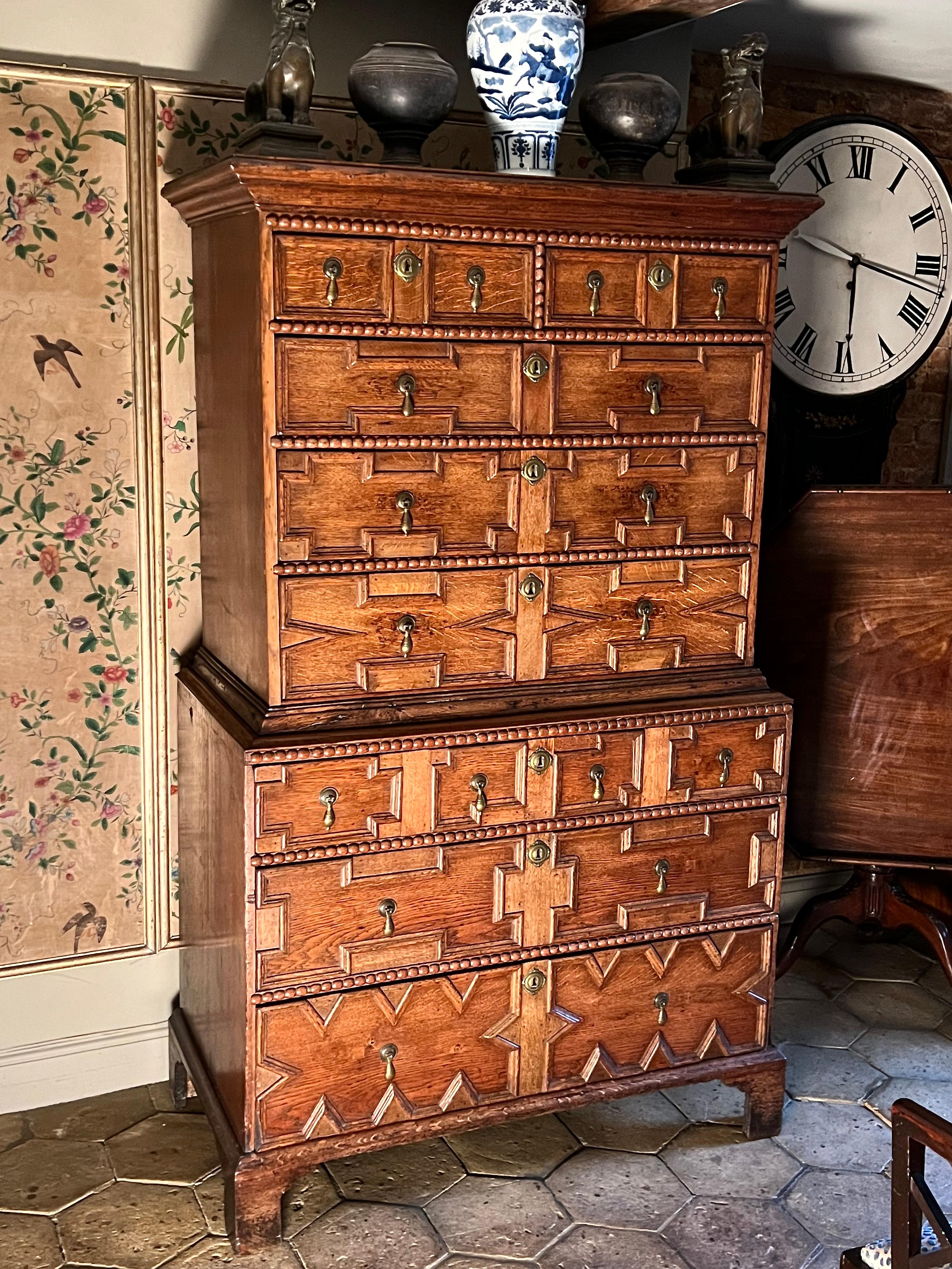 An English early-18th century oak geometrically-panelled chest on chest ca 1710-1720. Queen Anne / George I period.

NB. This is an interesting example of a transition from the late 17th century into the early part of the 18th century. Very often