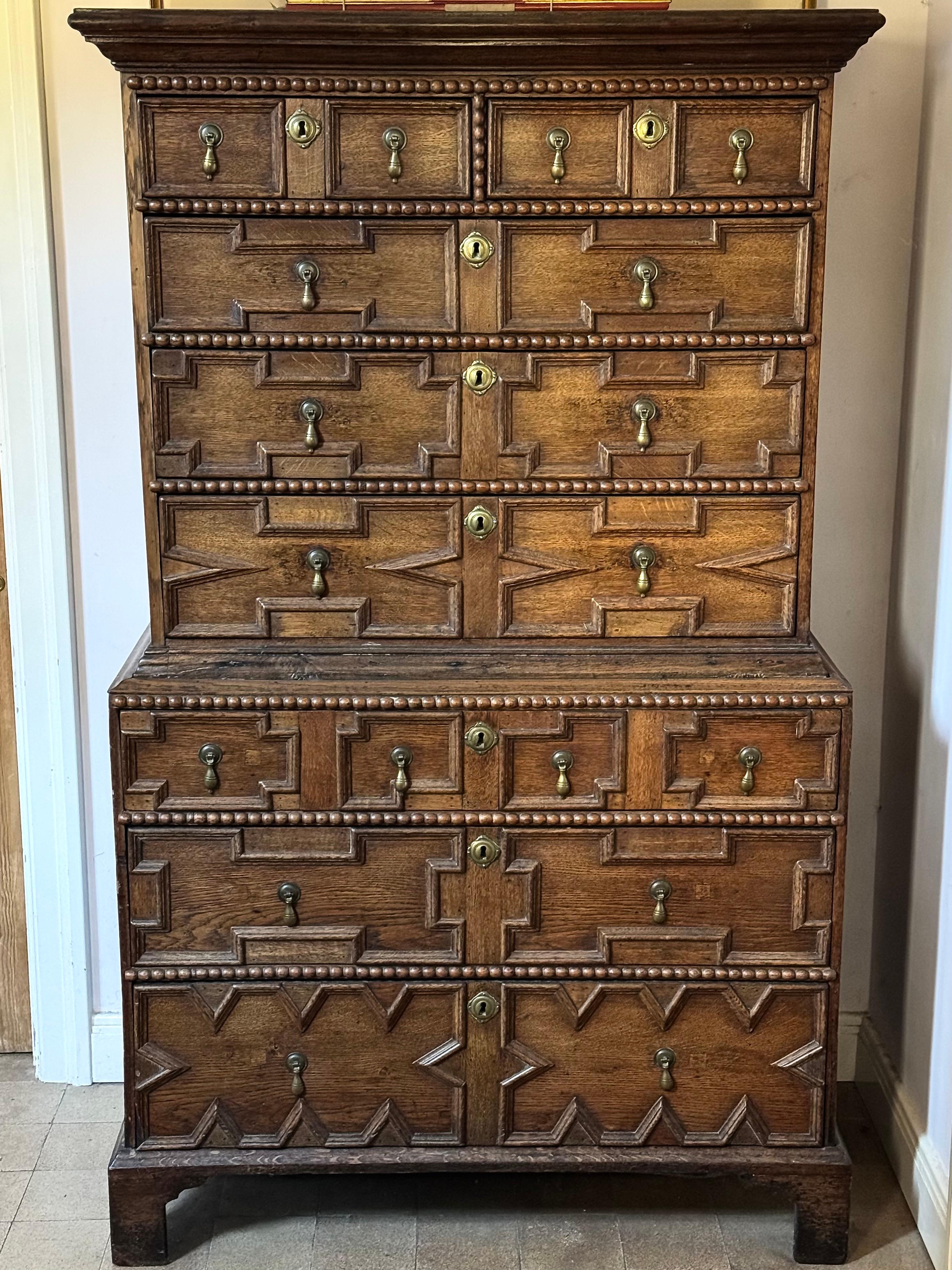 An English early-18th century oak geometrically-panelled chest on chest, ca 1710-1720.

Queen Anne / George I-period.

NB. This is an interesting example of a transition from the late-17th century into the early part of the 18th century. Very often