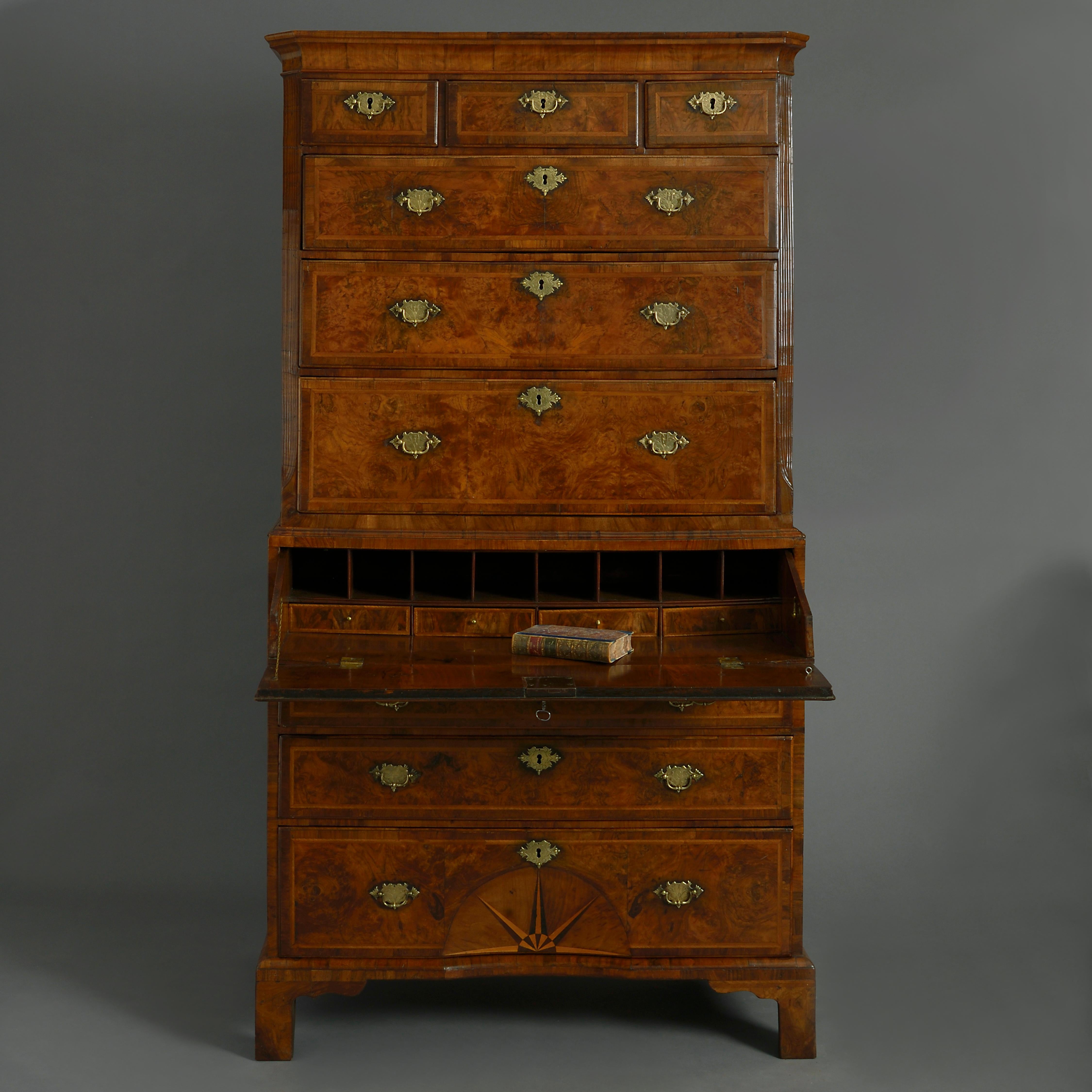 A fine early 18th century George I Period burr walnut secretaire tallboy, the shaped cornice above three short and three long drawers with herringbone inlay, crossbanding and etched brass handles and lock escutcheons, between fluted canted corners,