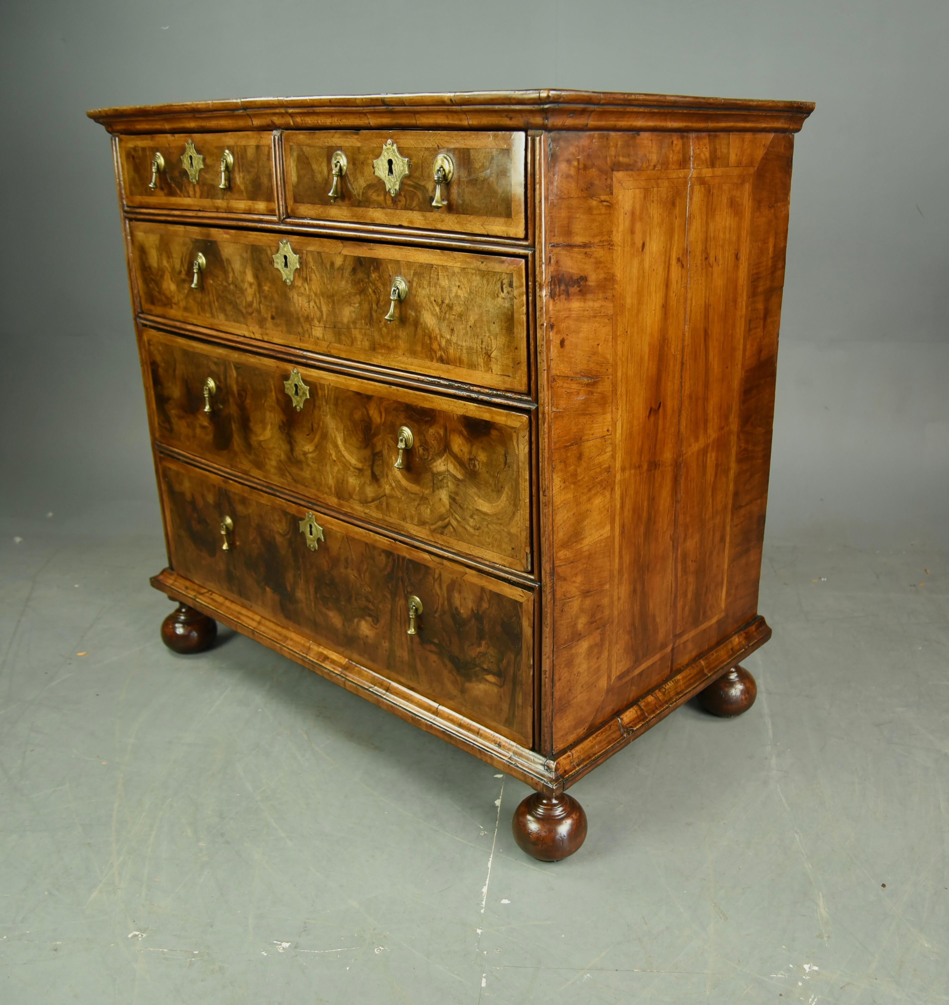 This Early Walnut Chest of Drawers presents with Beautiful Colour and great choice of Veneers 
Quarter Veneered top with cross banded edge.
Cross grained moulding's throughout.
Feather banded Drawer fronts and Good quality Oak Linings.
Sat on