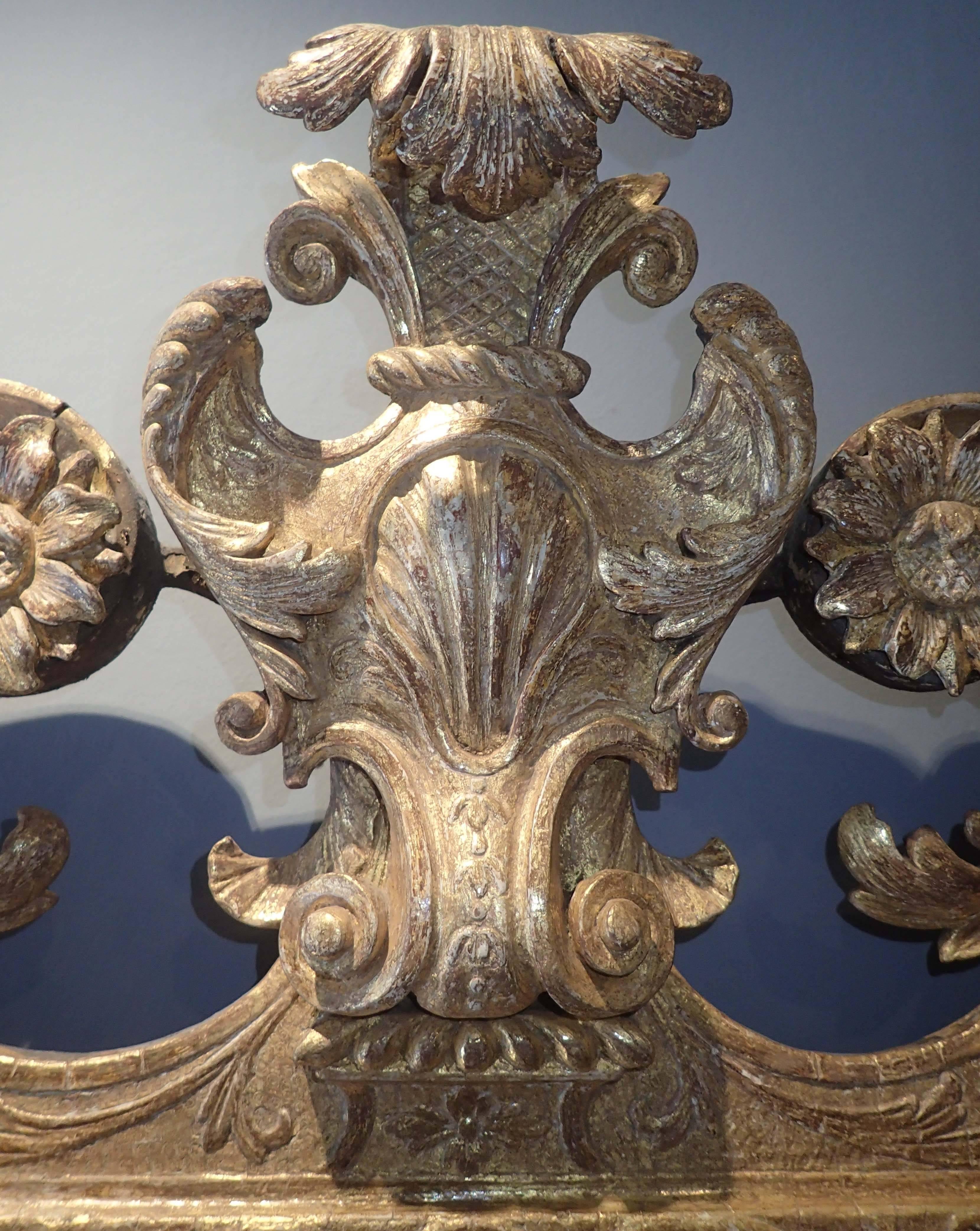 Original bevelled glass; original gesso and mainly original gilding.

This is a gorgeous early 18th century ‘gessowork’ (or just ‘gesso’) mirror. The basic outline is unremarkable for the period, swan neck pediment, cartouche, straight sides; but