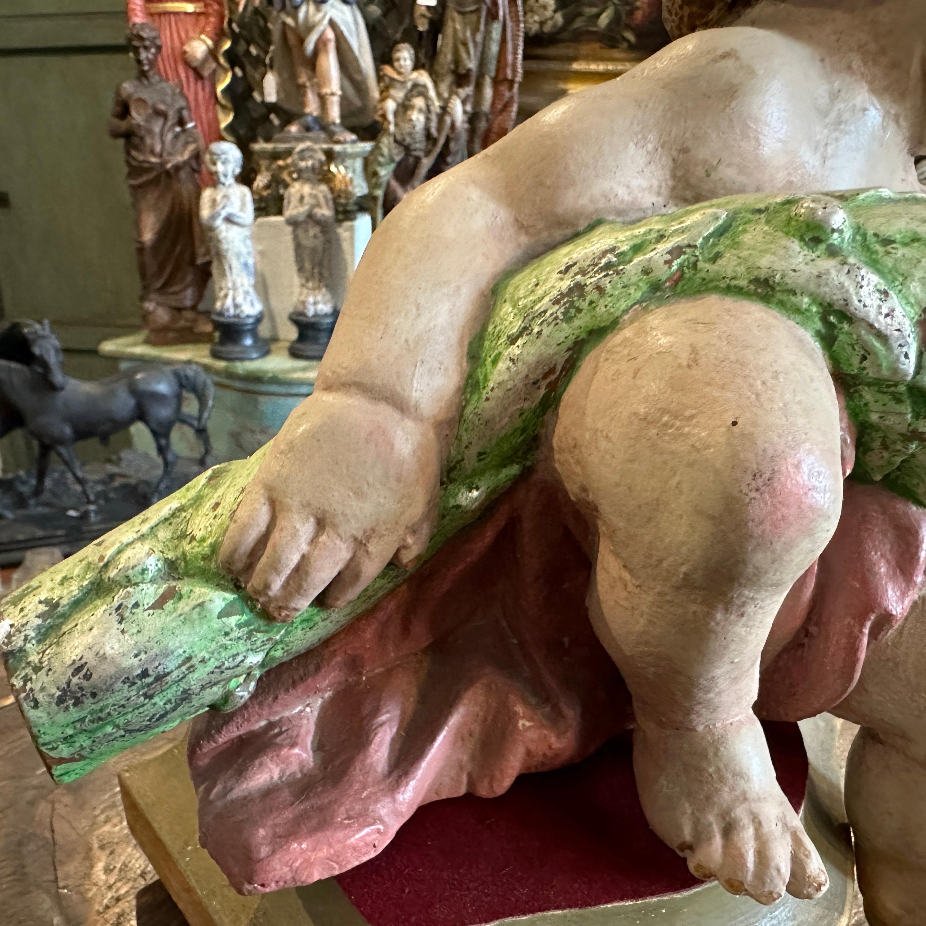 Scultura in legno laccato raffigurante un Cherubino seduto, scolpita e dipinta a mano in Italia all'inizio del XVIII secolo. Il cherubino è stato montato alla fine del XIX secolo su una base di Wood. È in condizioni originali, con normali segni