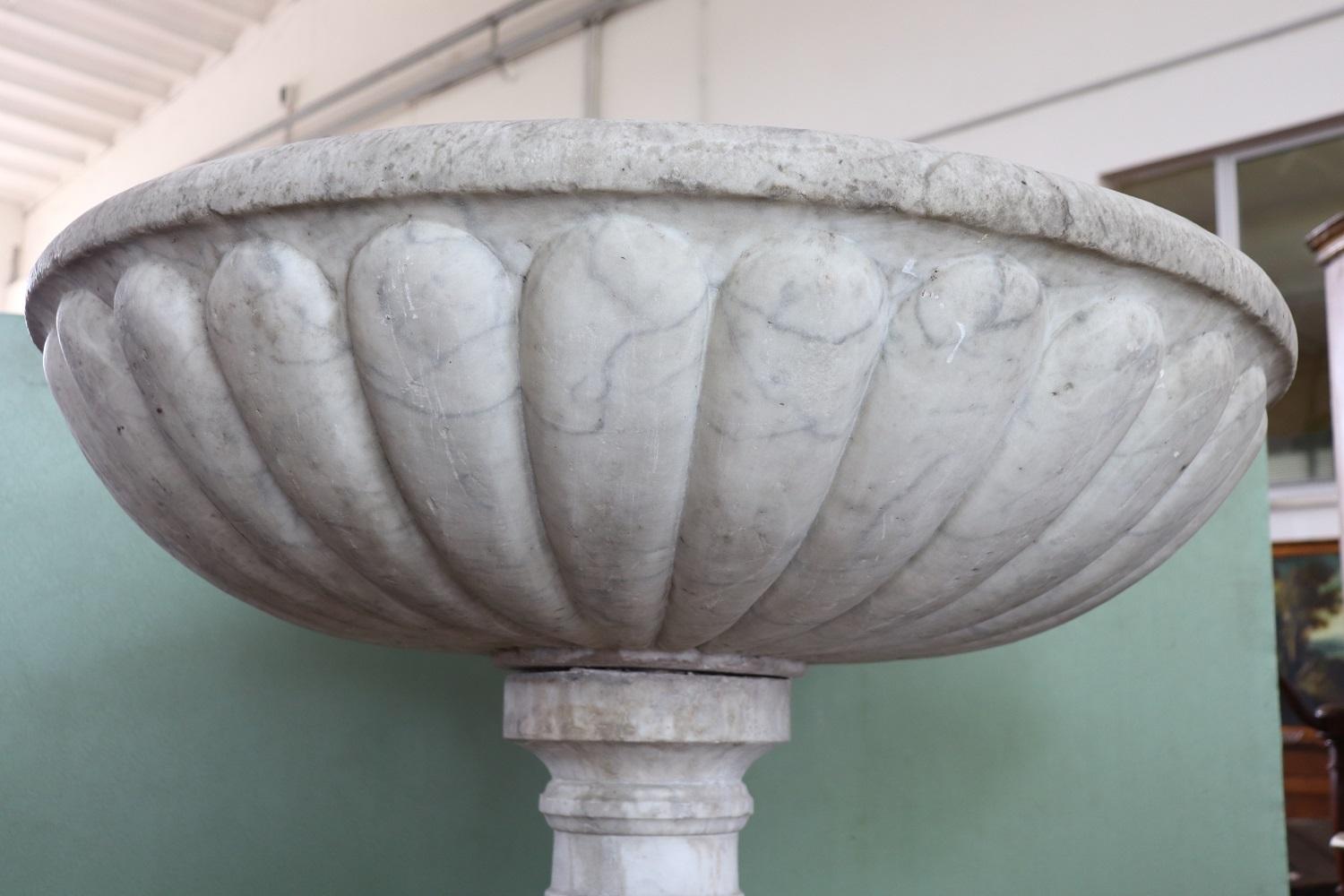 Rare Italian antique hand carved marble font. Made of fine hand-sculpted Italian white Carrara marble. The column has a beautiful turning. The large basin has a typical Baroque decoration called bacellatura which consists of a typical process