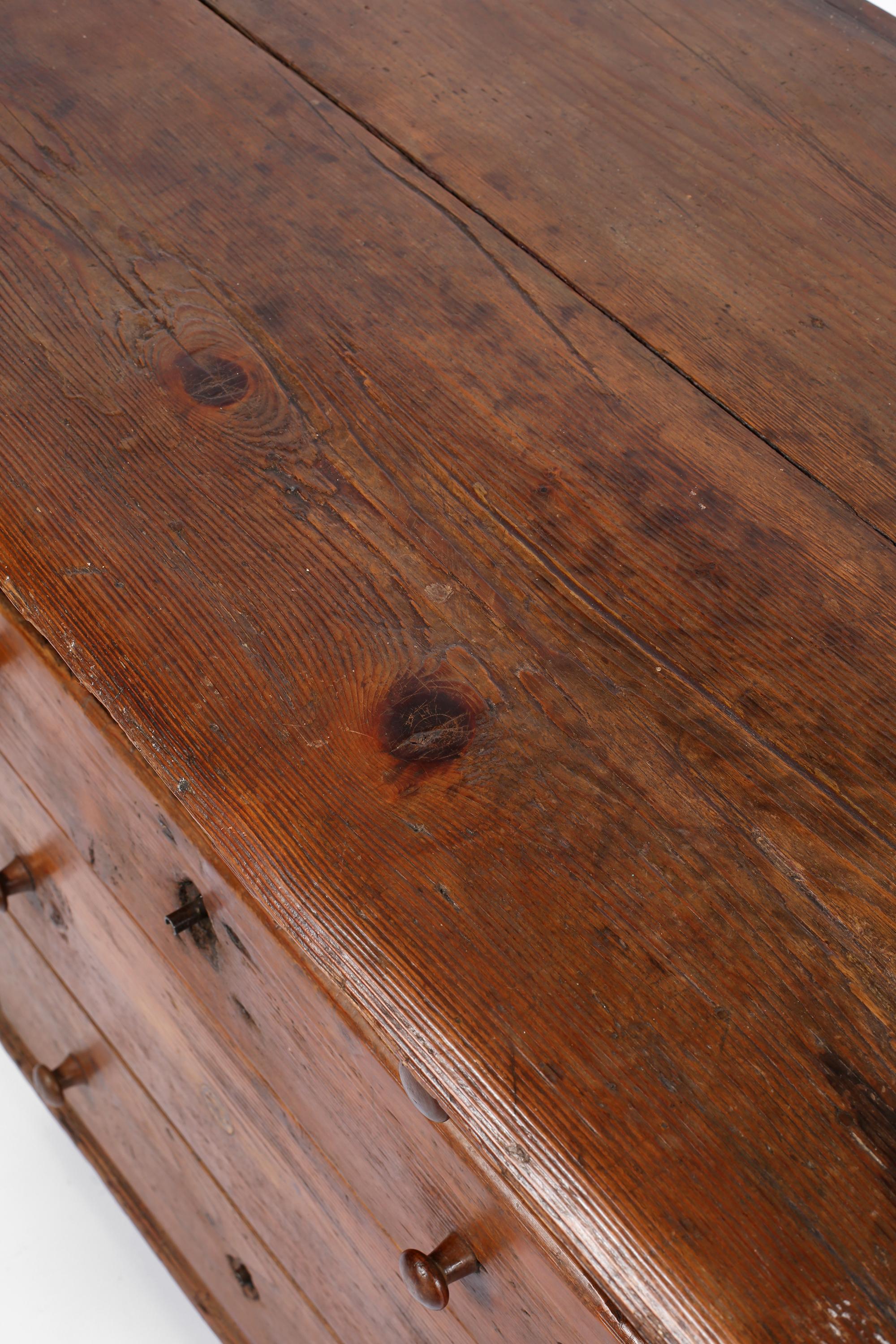 A charming early 18th century chest of drawers from the Veneto region. Constructed from patinated pine & elm timbers, the chest features a tactile two-plank overhanging top, four graduating drawers and its original turned feet. Italian, circa 1700.