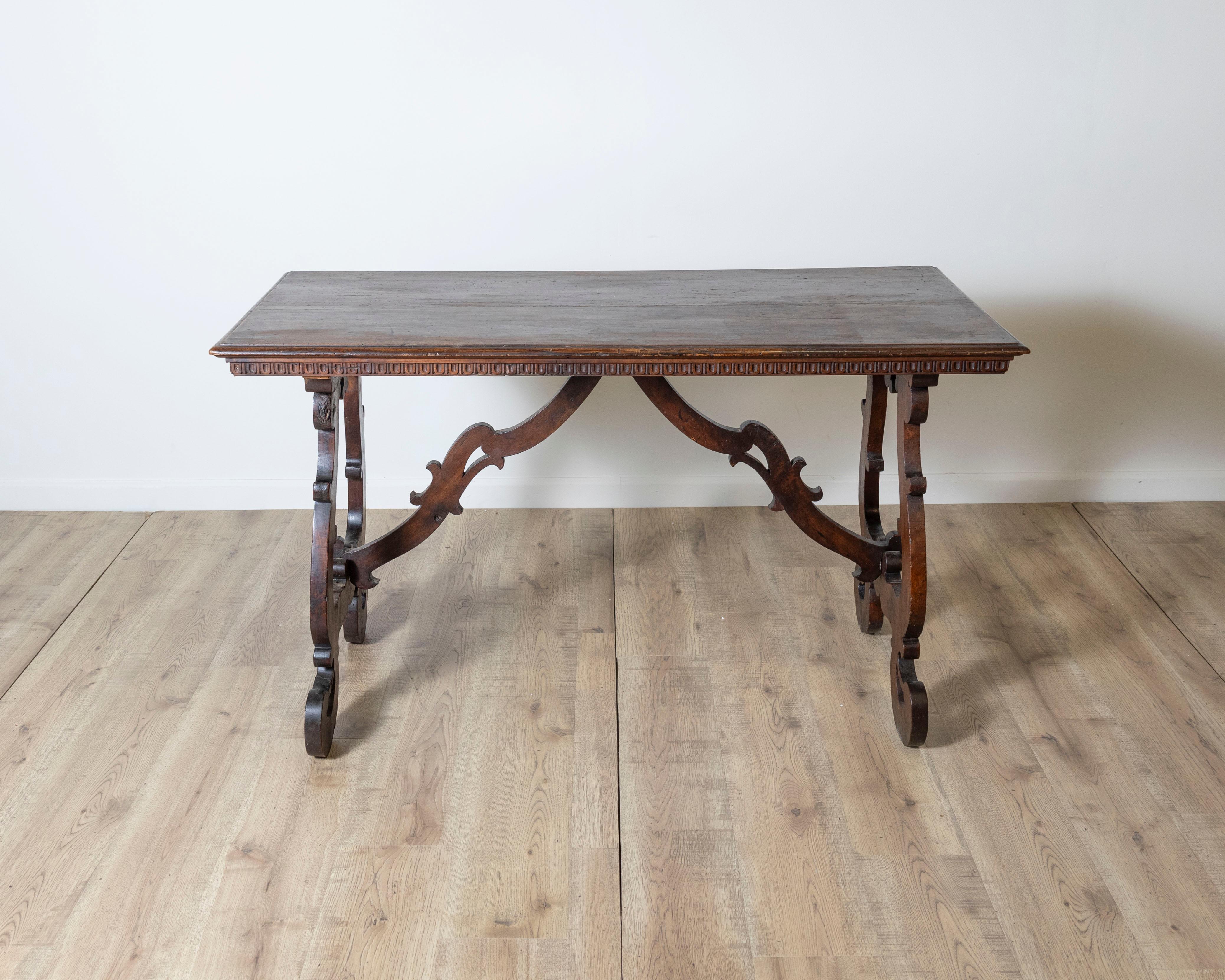 Une imposante table fratino ombrienne en noyer massif, datant d'environ 1720. Cette table de réfectoire du début du XVIIIe siècle présente un plateau rectangulaire avec un bord en denticule finement sculpté, un détail subtil mais élégant qui met en