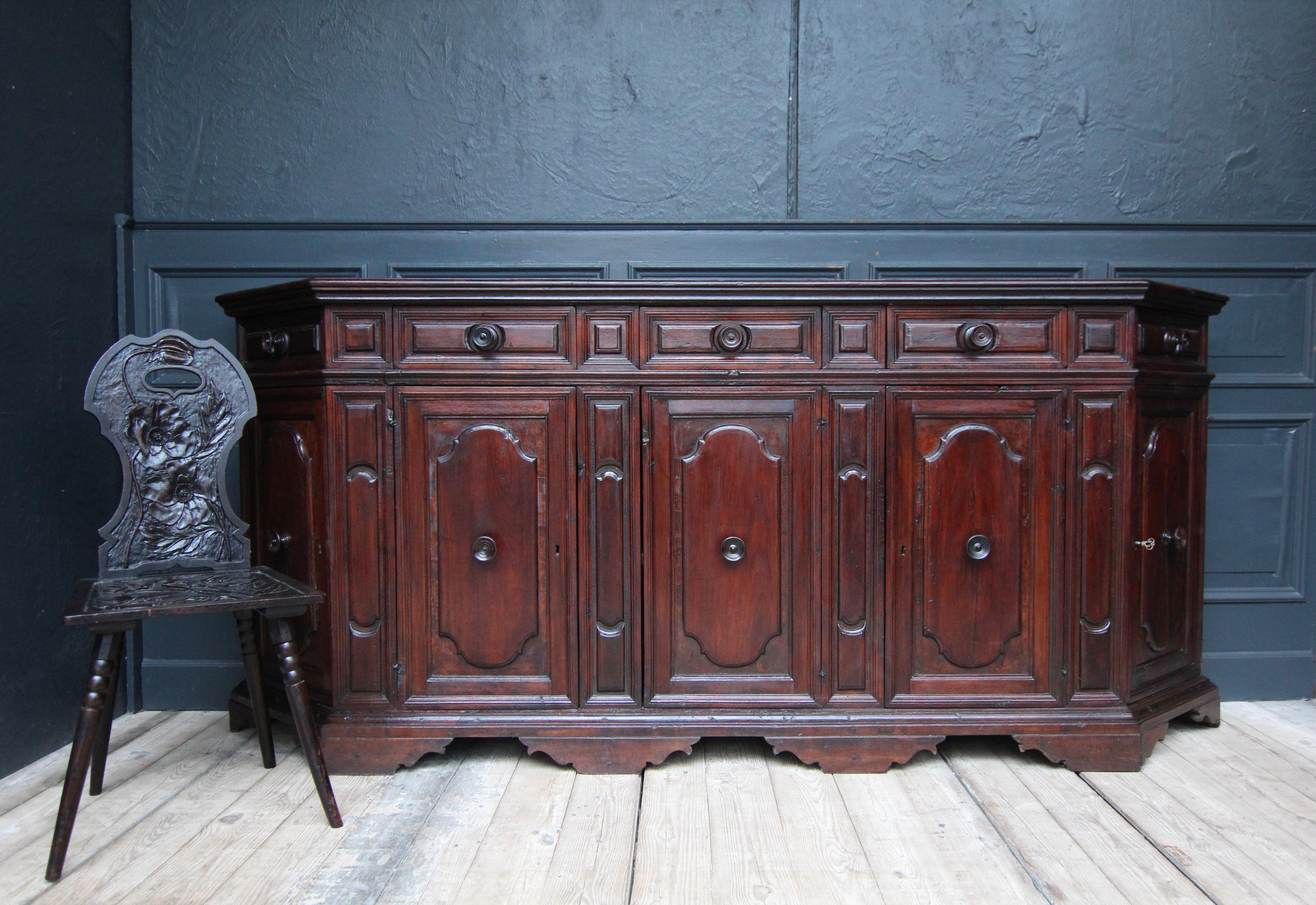 A early 18th century Italian Baroque Scantonata credenza or enfilade in nutwood.

Rectangular nutwood corpus on bracket feet with bevelled sides and a profiled top. A total of 5 doors and 5 drawers, each with a round turned knob.

Dimensions: