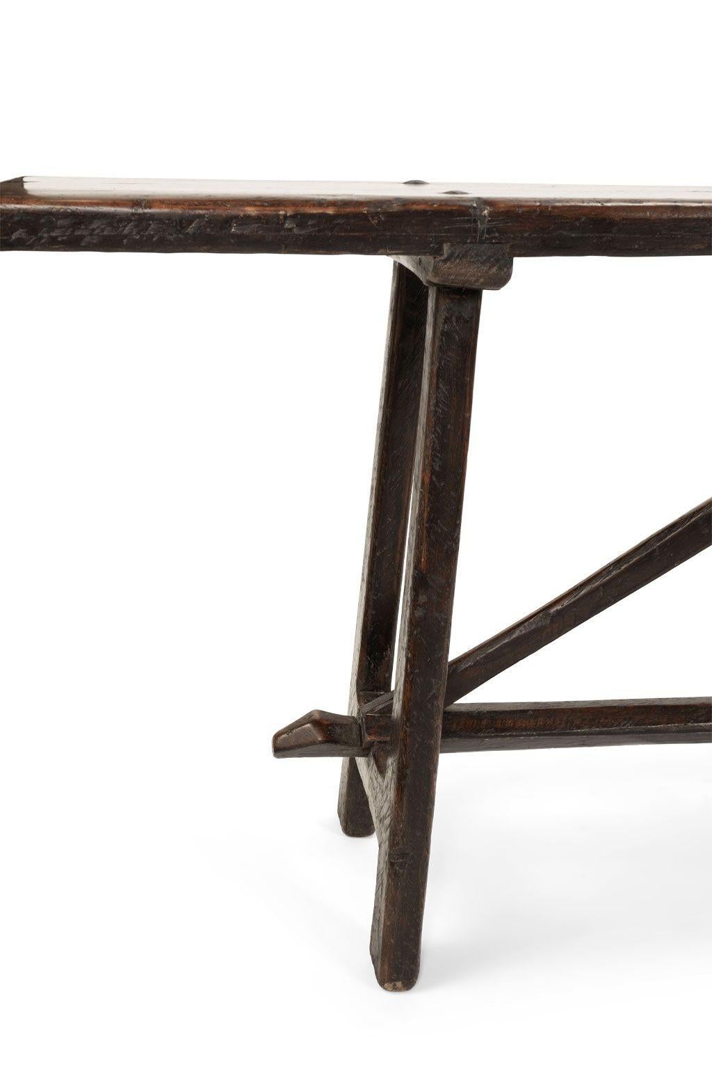 Early 18th century Italian walnut console with beautifully shaped trestle (circa 1720-1749). Hand-planed with chisel marks across underside of top. Mortise and tenon joints.