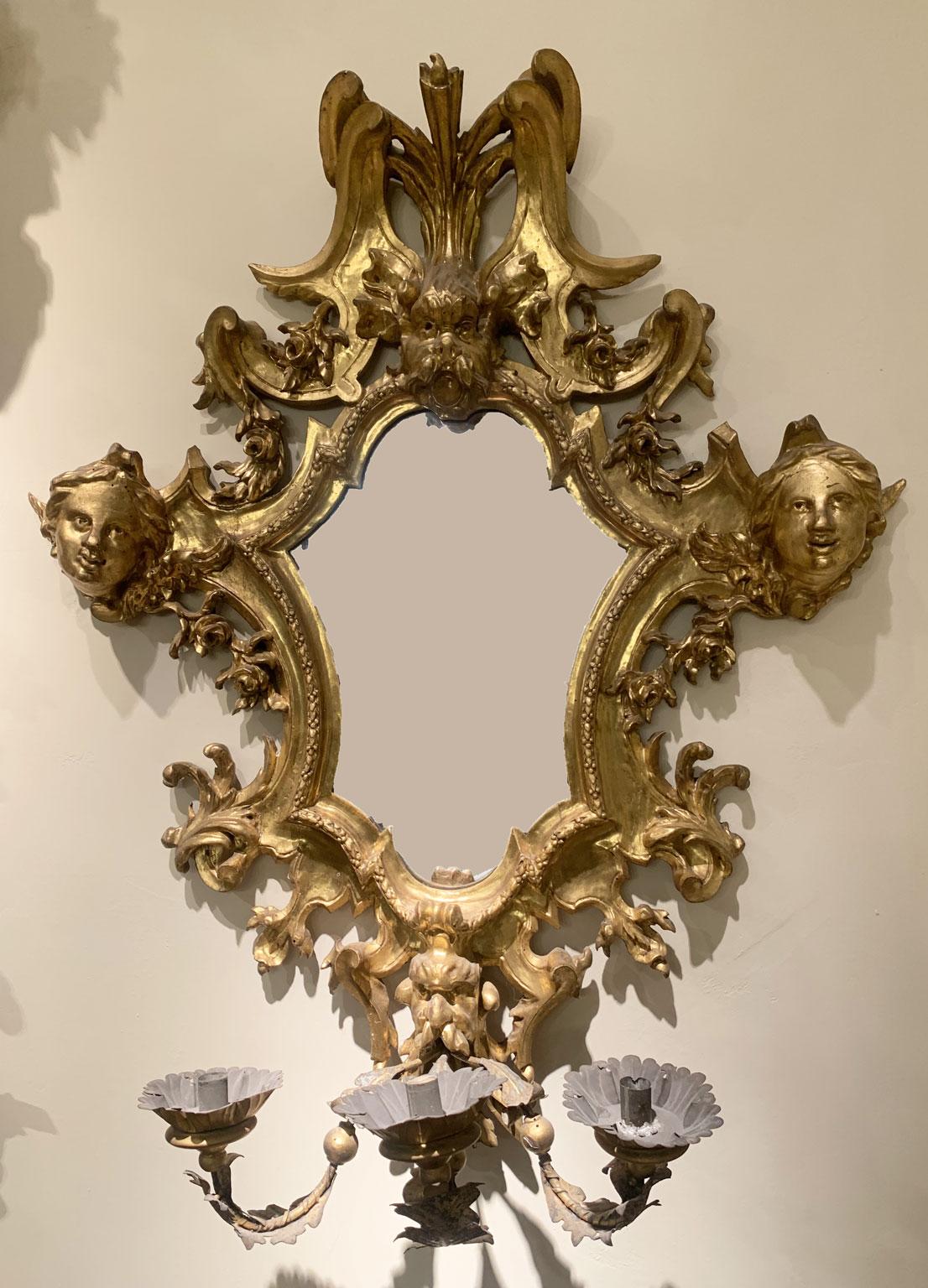 Se trata de una exquisita pareja de espejos de pared dorados, esculpidos y tallados, con candelabros de hierro.
Este par de elegantes espejos de pared proceden de principios del siglo XVIII, de Lucca, Toscana, Italia. Los espejos muestran una