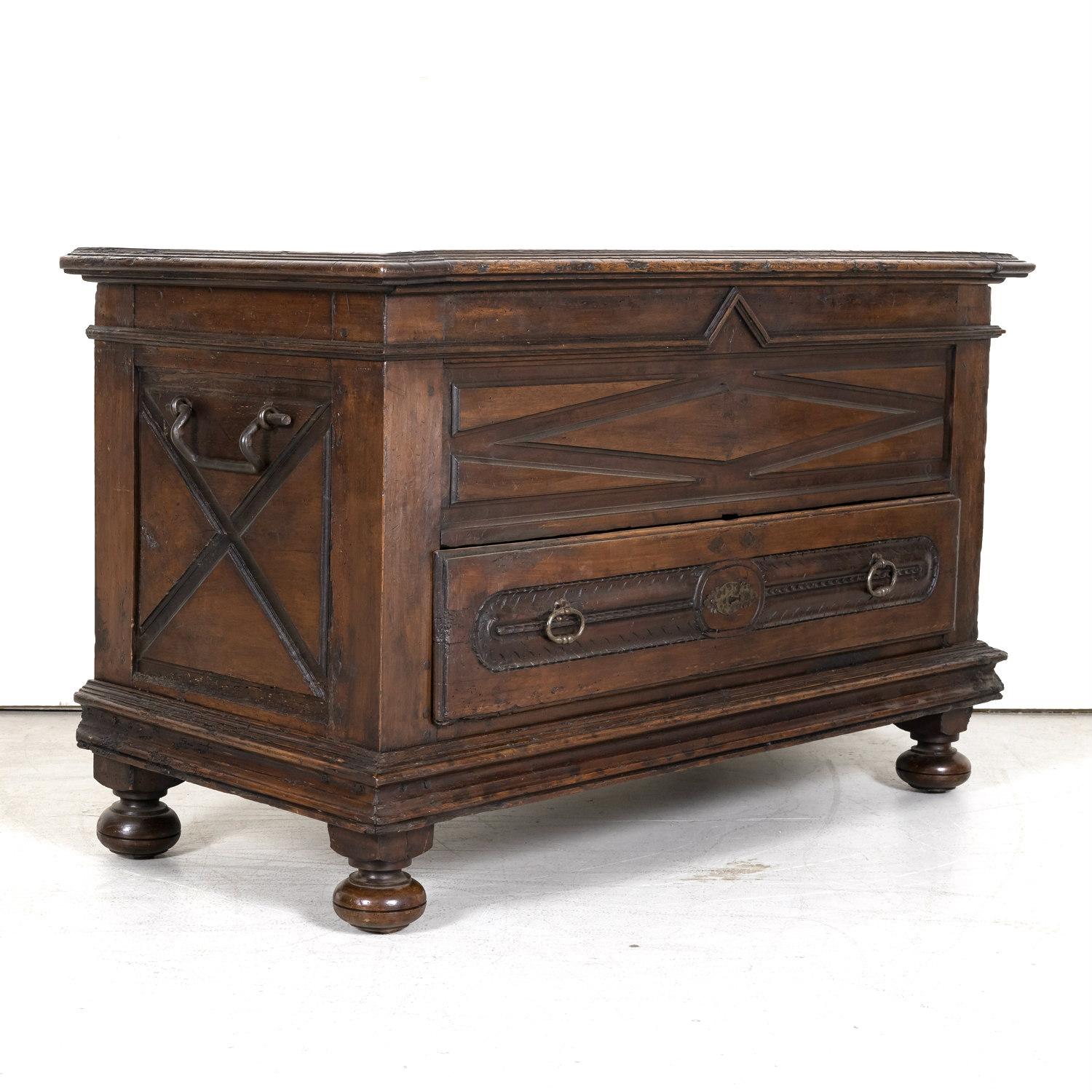 An early 18th century Louis XIII style coffer or trunk handcrafted of solid old growth French walnut having a beautiful rich and dark color patina, circa 1710. This handsome trunk features typical Renaissance style geometric carvings like the raised