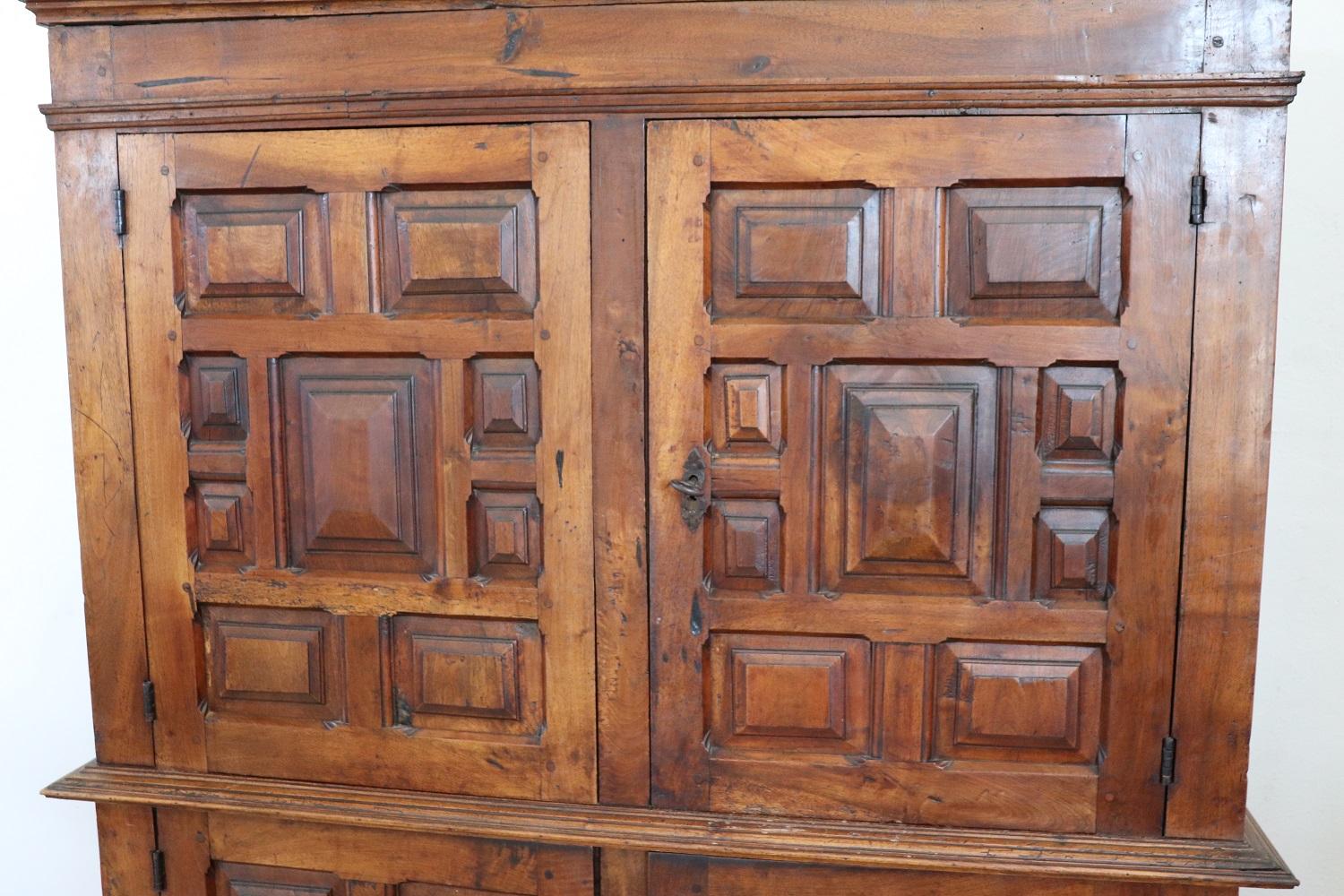 Rare et important cabinet ancien en noyer massif réalisé au début du 18ème siècle en Italie par Louis XIV. La ligne est en effet typique de cette période de haute époque qui voulait ce type de mobilier de grande grandeur en bois de noyer massif. Au