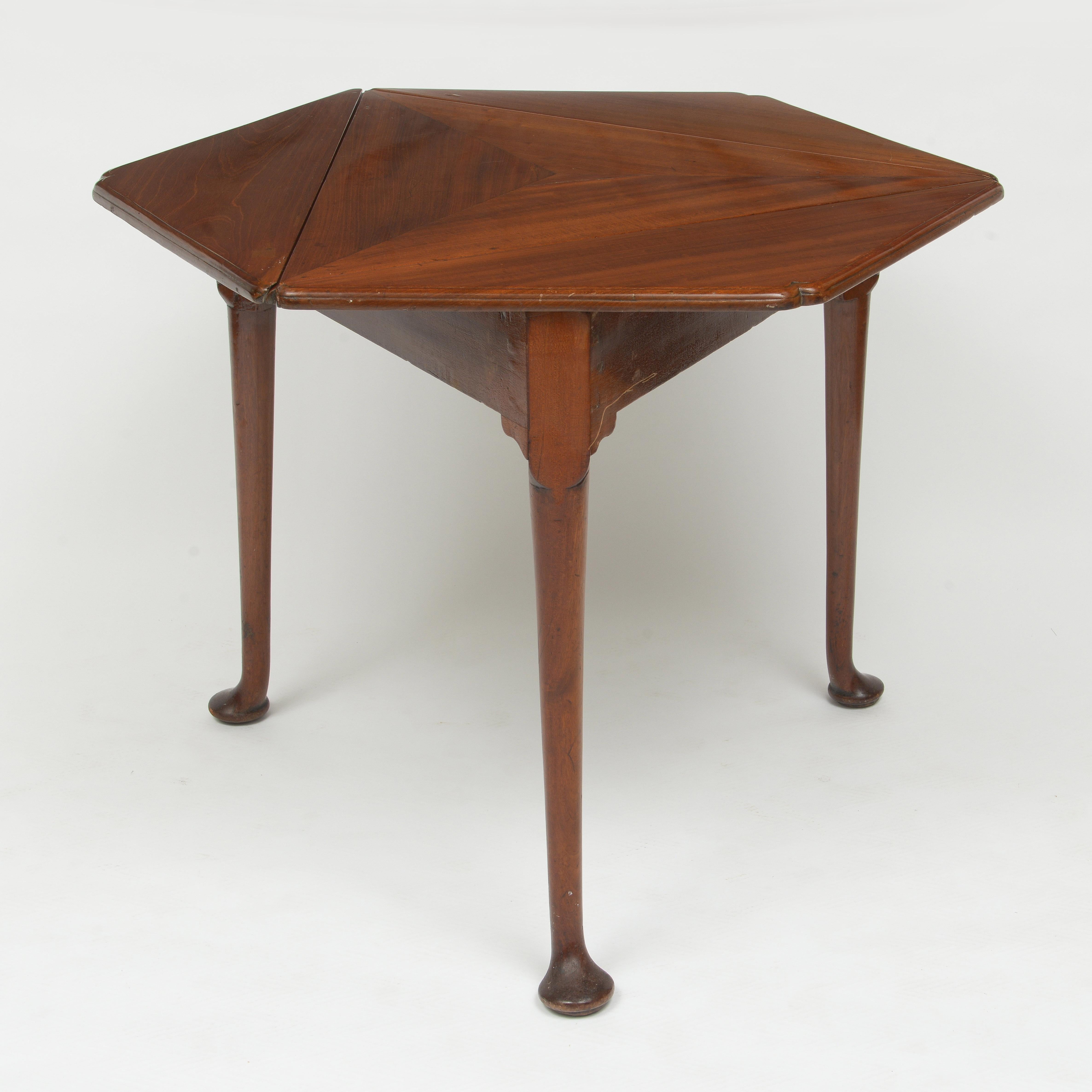 Triangle or hexagonal table
Leaves close as the top is rotated
Can be an accent table of small tea table or card table
Finely figured mahogany with carved dimple corners.
Legs are turned terminating in a pad foot.