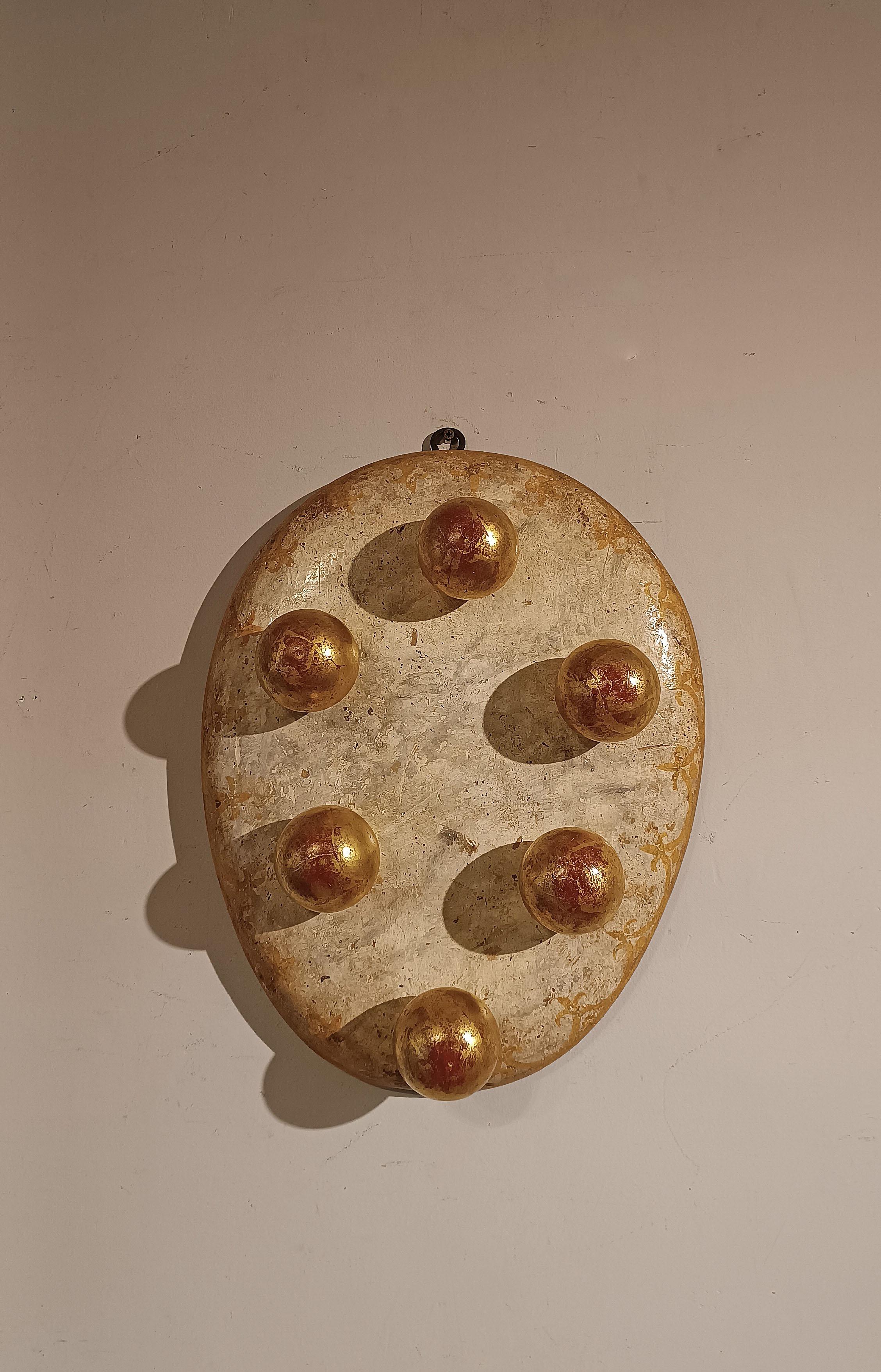 Espléndido e histórico escudo de madera pintada, adornado con elegantes remates de hierro dorado. El escudo está pintado con un fondo de imitación de mármol y presenta delicados adornos en forma de lirio a lo largo del borde. Se trata del escudo de