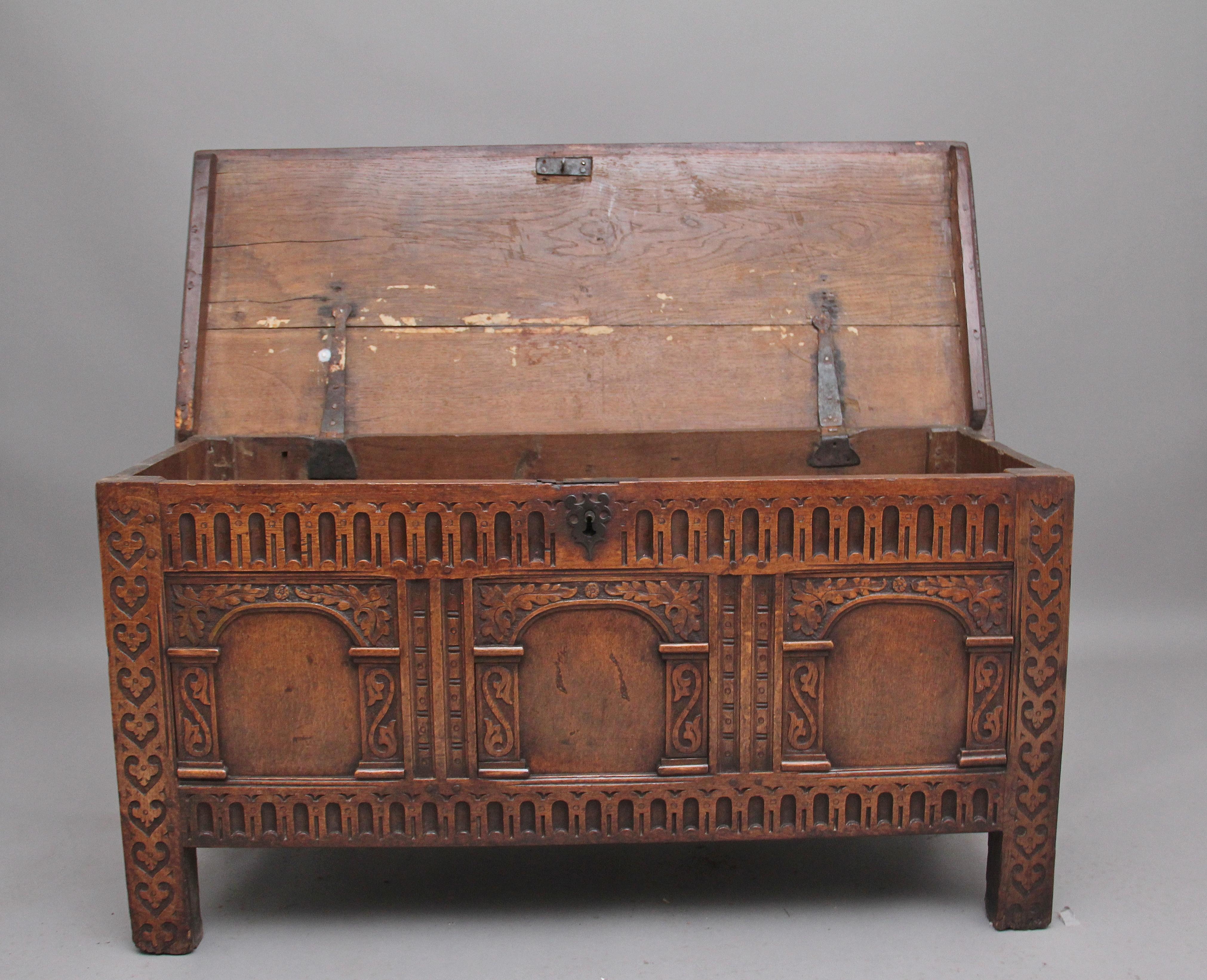 18th century oak coffer with the hinged top opening to reveal a large compartment space, above a three panelled front with carved decoration, wonderfully carved rails, standing on square legs, Circa 1720.
 