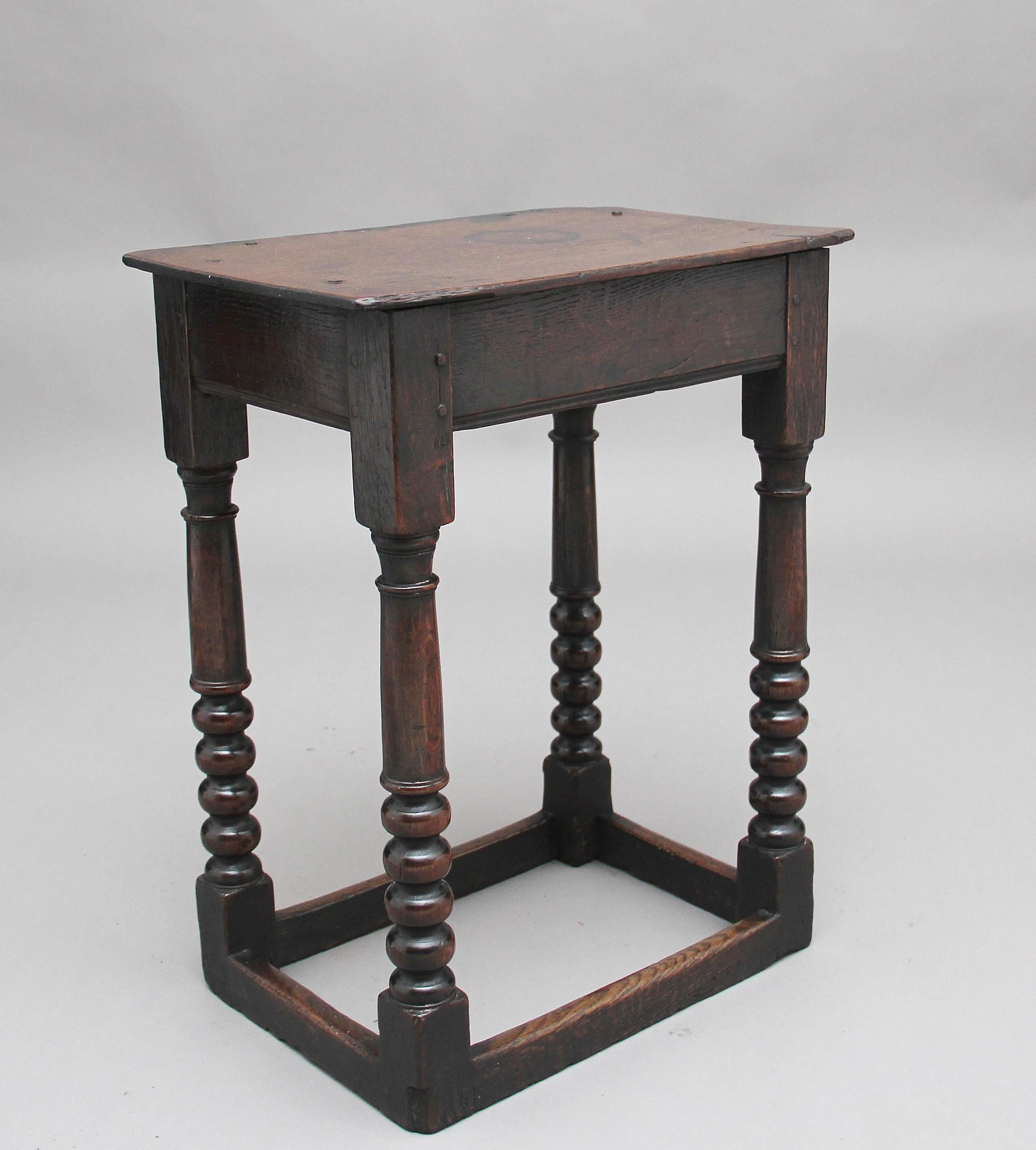 Early 18th century oak joint stool, the rectangular solid top above a deep frieze with a reeded edge, supported on four bobbin turned legs united by plain cross stretchers, circa 1720.
 