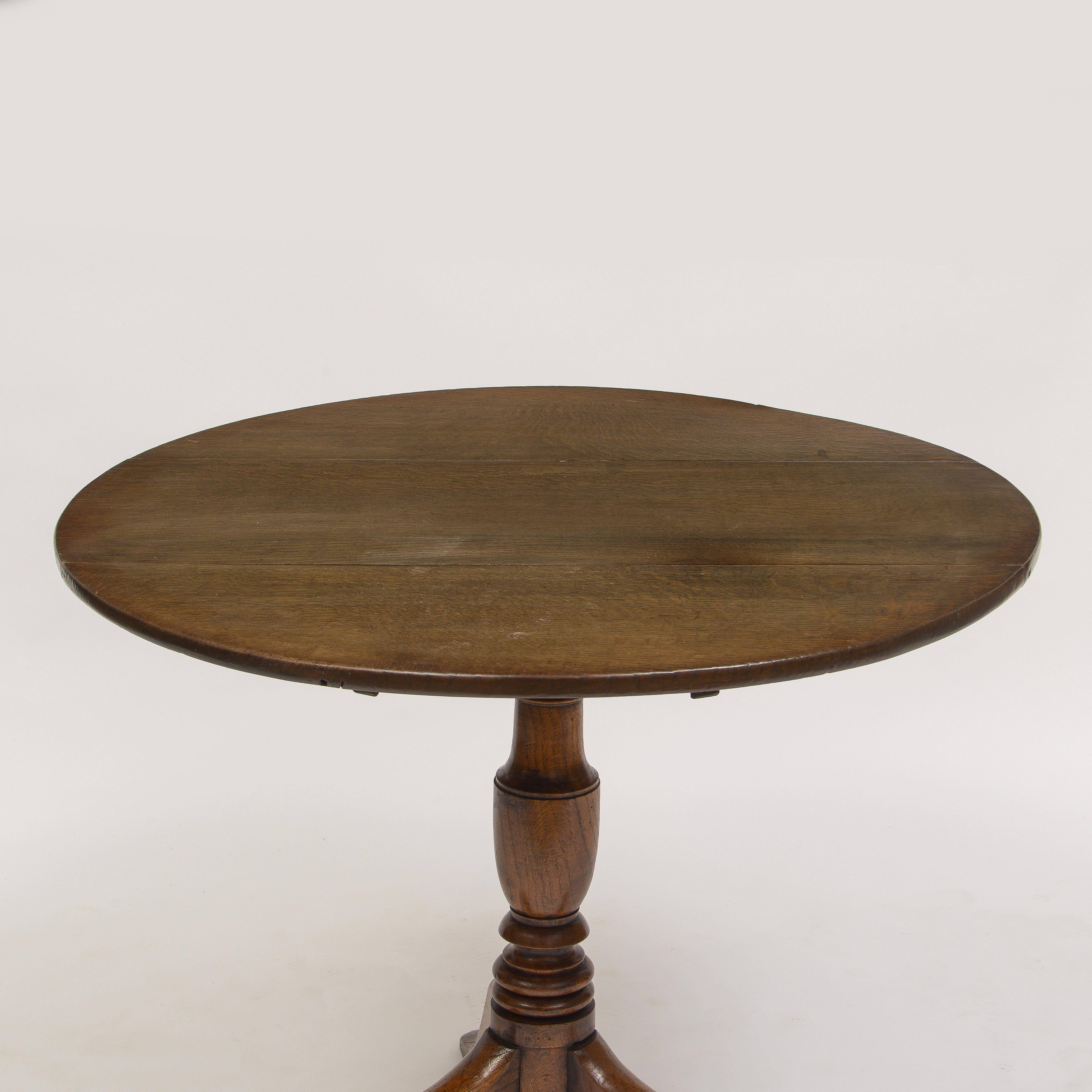 Beautiful bleached brown oak top with appropriate patina
Supported by a turned pedestal and three legs in the shape of human legs with shoes.