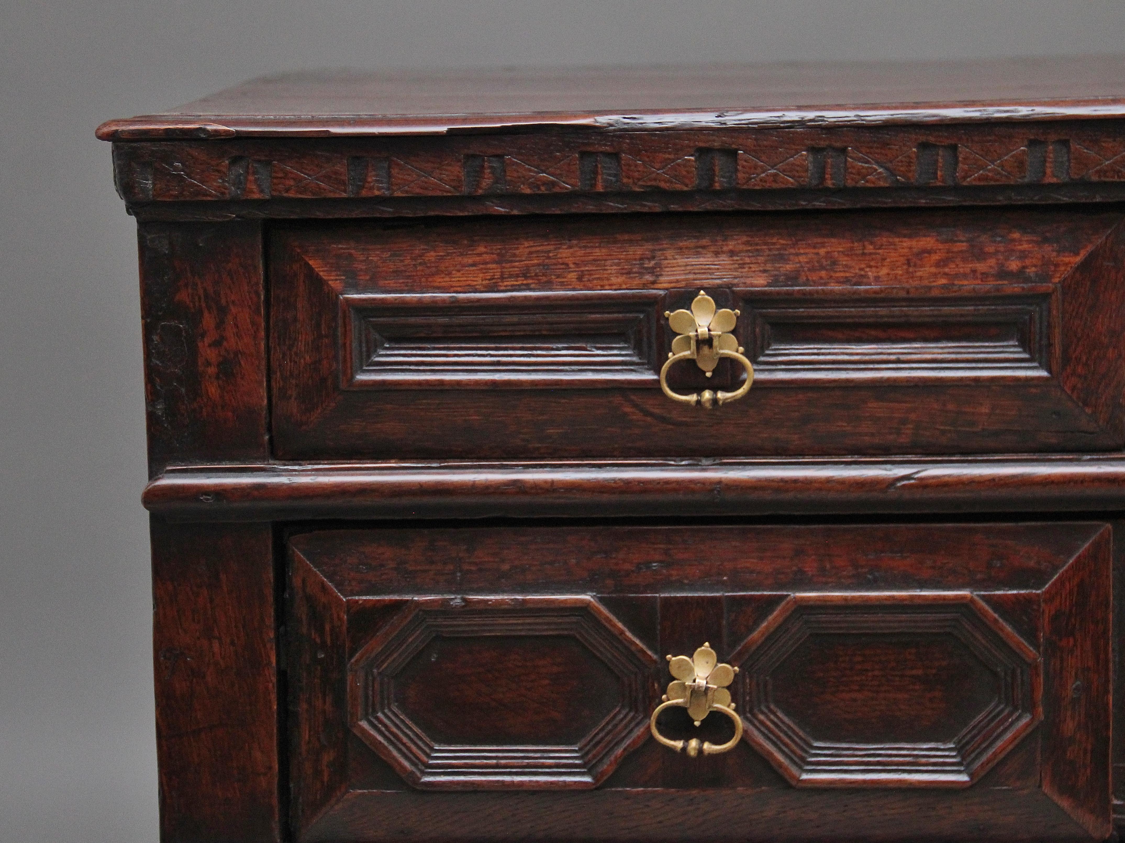 Early 18th century oak moulded front chest of drawers from the Stuart period, the rectangular top with a decorative carved frieze along the front and sides, with a combination of two short over three long graduated oak lined drawers with the drawer